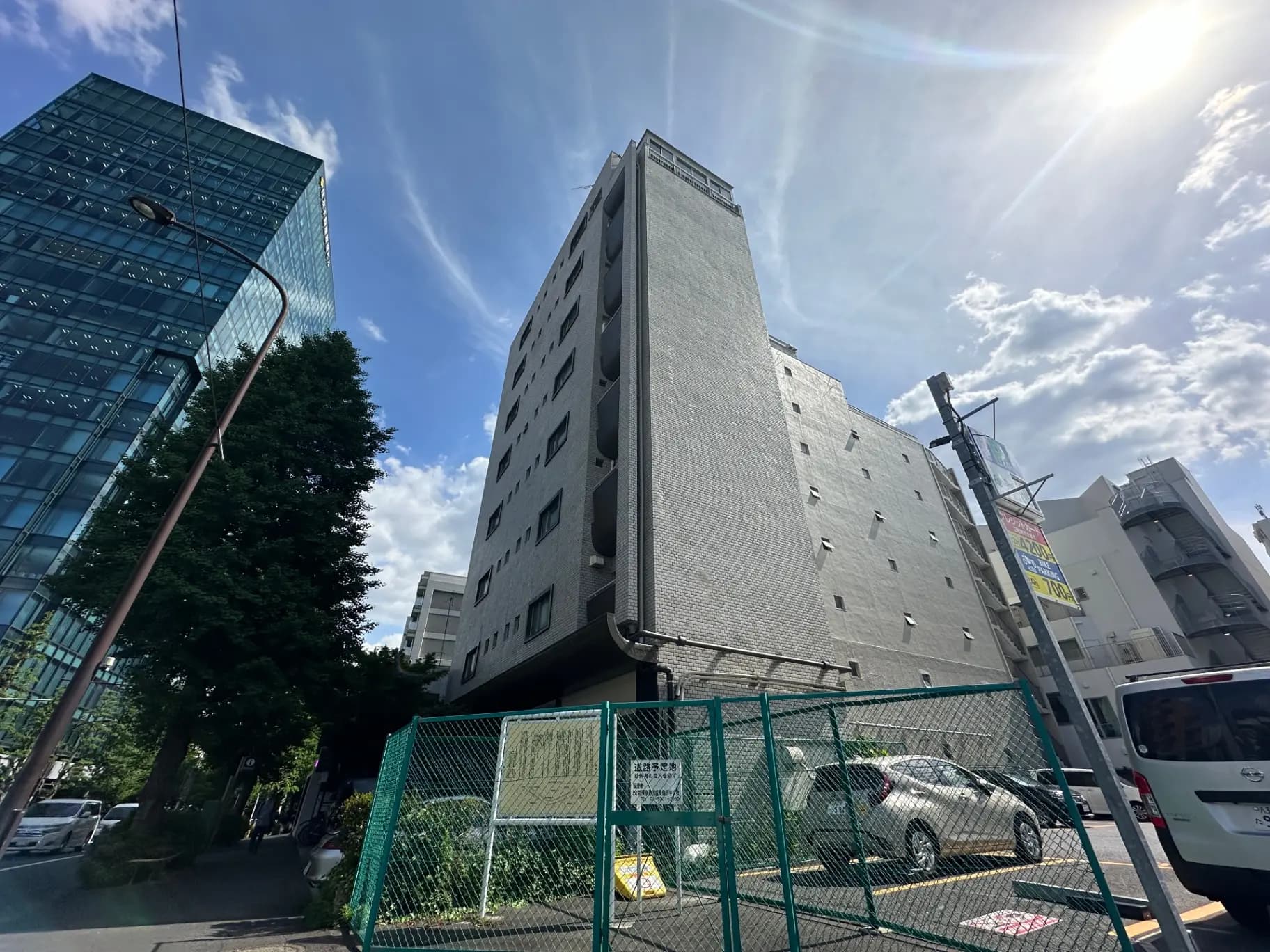 都心の高層ビルと低層アパート、晴れた日の青い空と太陽光線、都会の建築物と自然のコントラスト