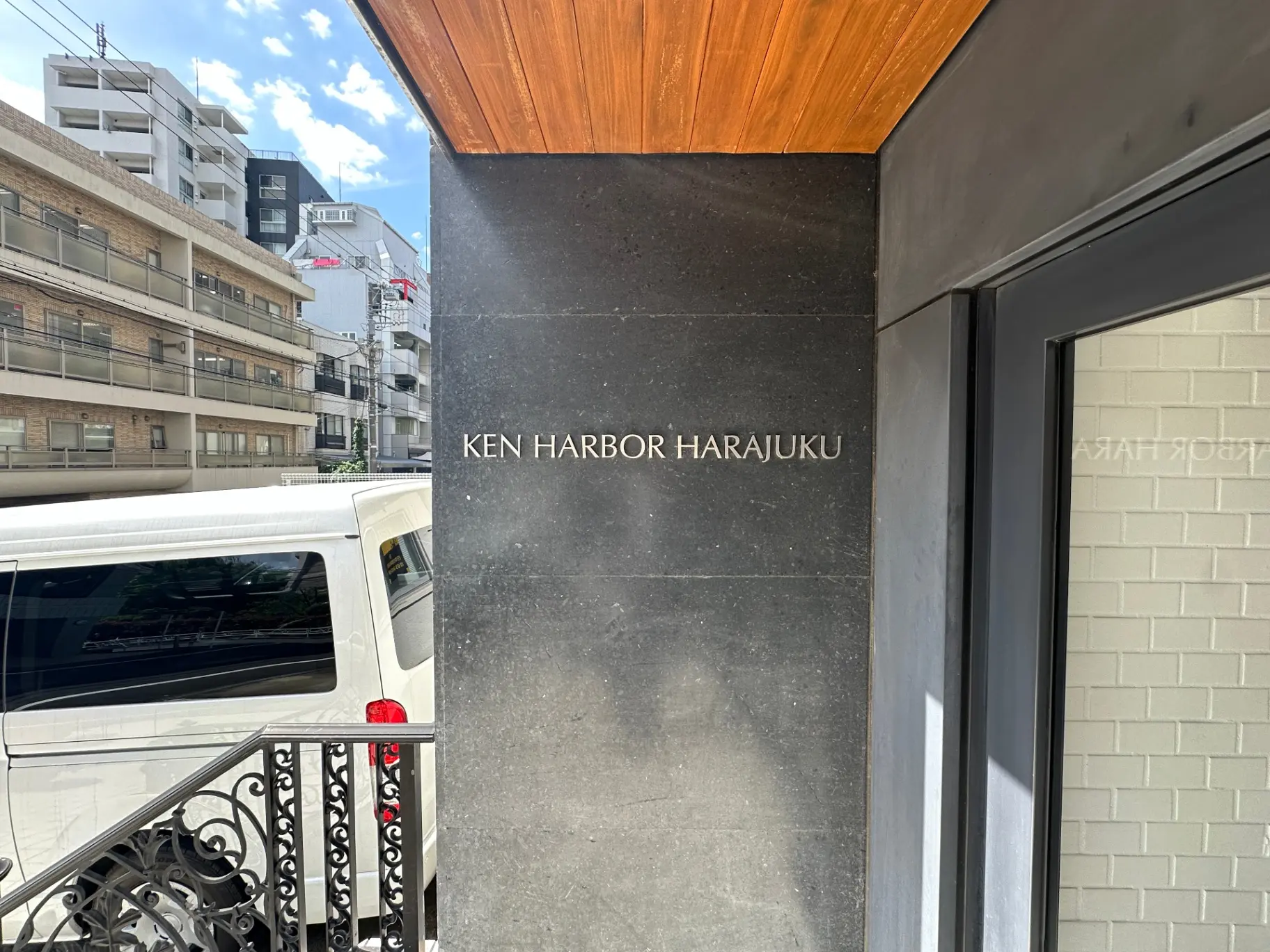 原宿のKEN HARBOR HARAJUKUの入り口、黒い大理石の壁、木目の天井、白い車と建物