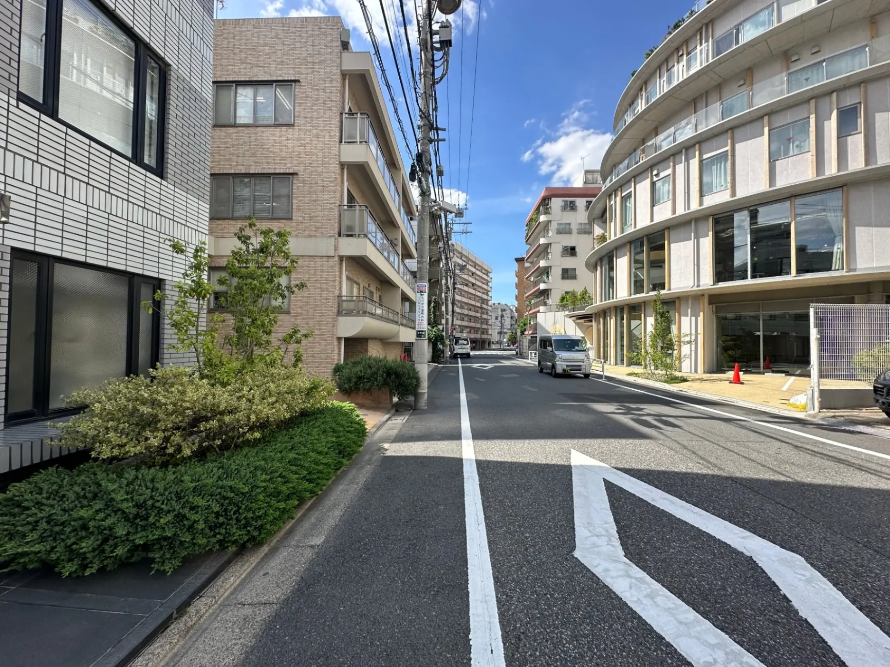 日本の都市部の静かな住宅街、白線が引かれた舗装道路と近代的な建物