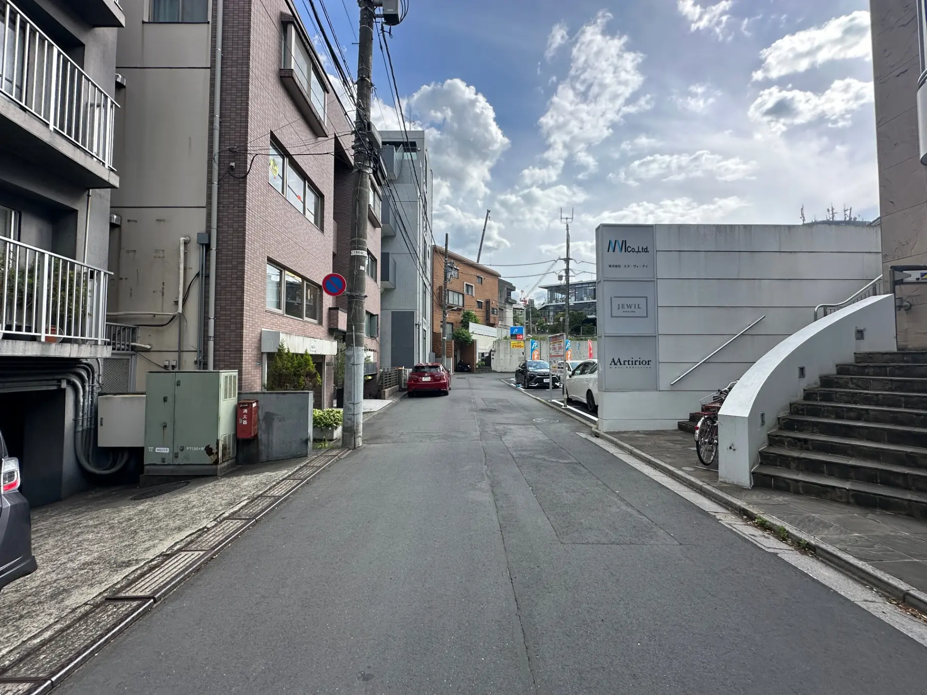 晴れた日の都市の道路、ビルの間を走る自動車と通りに面した階段