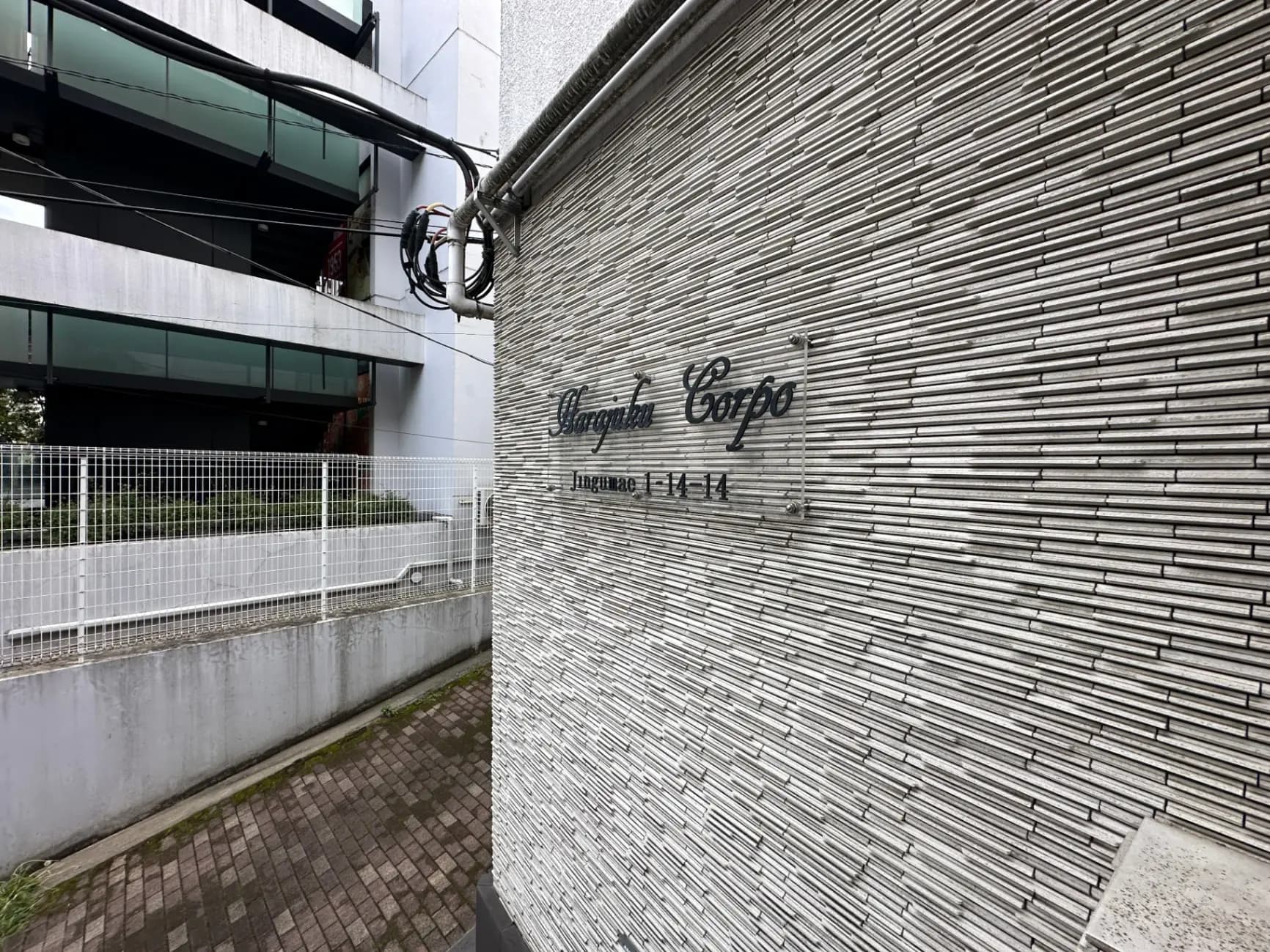 モダンなビルのエクステリア、ストライプ模様の壁、建物名称の「Hooper Town Corpo」の看板