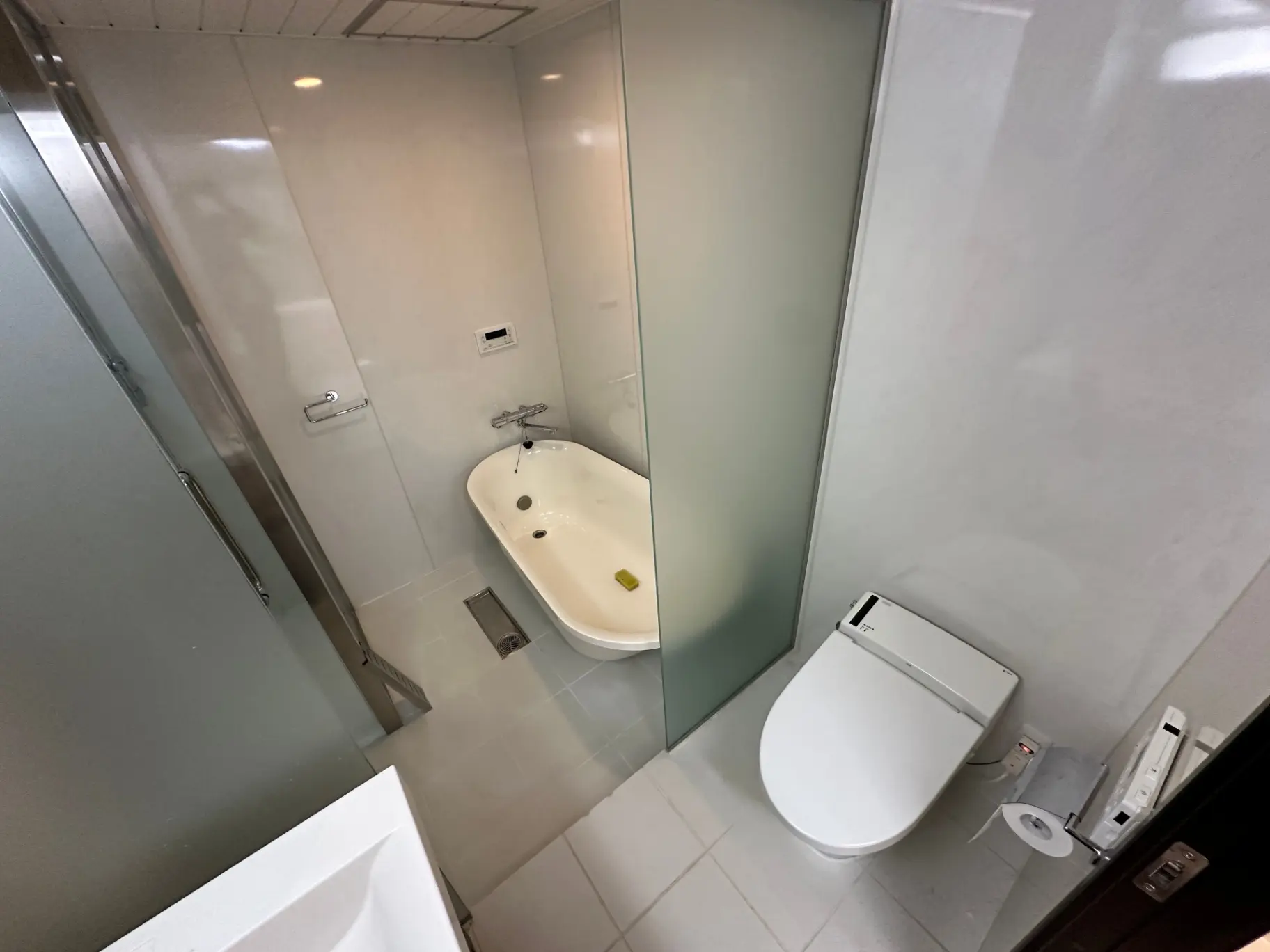 モダンなバスルーム、ガラスのシャワーキャビン、白いバスタブ、清潔感のあるトイレと洗面台