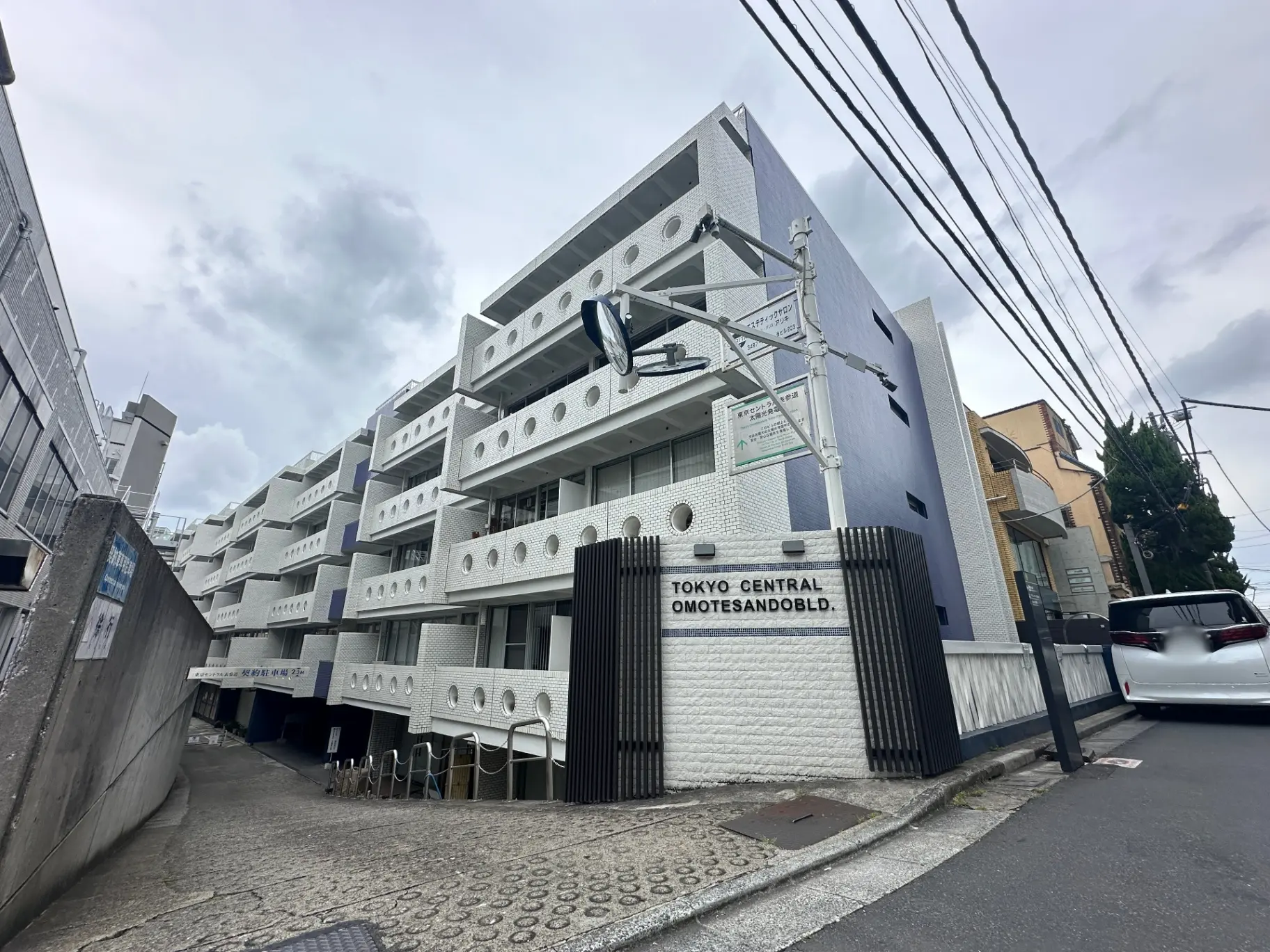 東京セントラル表参道ビルの外観、モダンなデザインの白い建築物、曇り空の下の都会的なストリートビュー