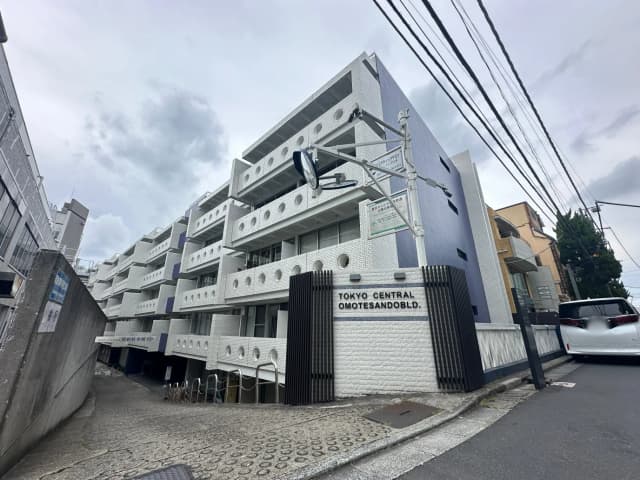 東京セントラル表参道ビルの外観、モダンなデザインの白い建築物、曇り空の下の都会的なストリートビュー