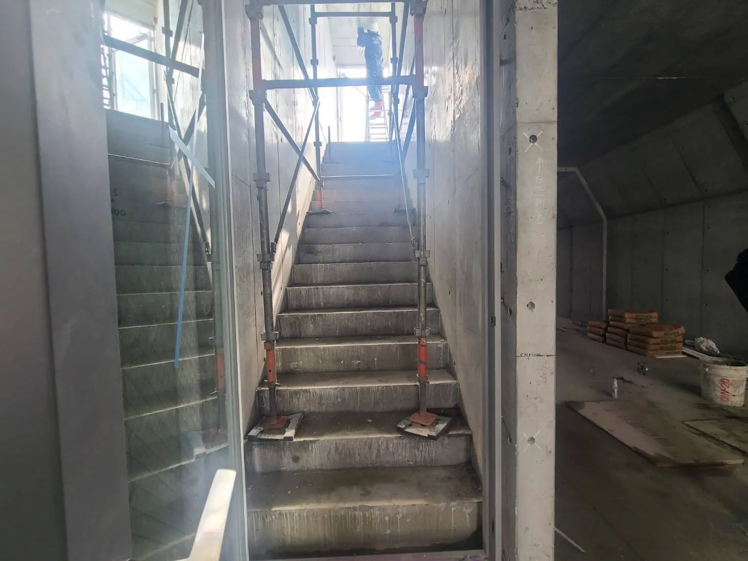 建設中の建物内のコンクリート階段、作業現場の材料が見える