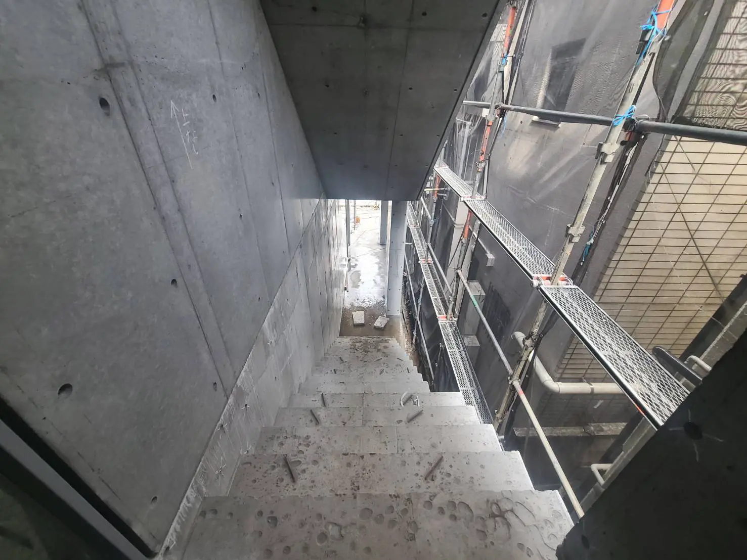 建築現場のコンクリート通路と保安用の柵、建設途中の構造体