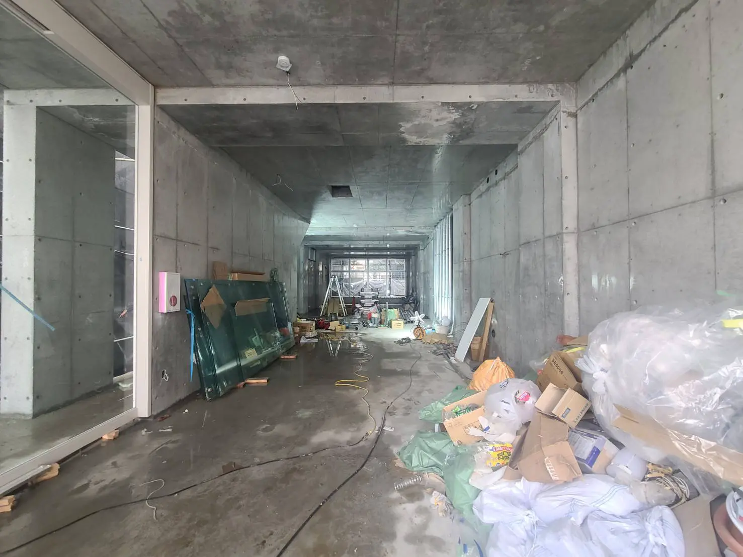 工事中の建物の内部、コンクリート壁と床、散乱している建設材料と工具