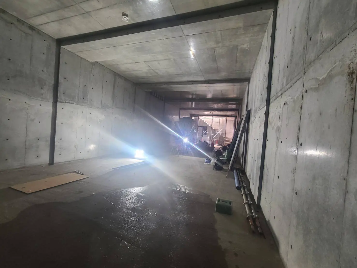 未完成の建設現場のコンクリート構造、作業灯からの光が床に反射