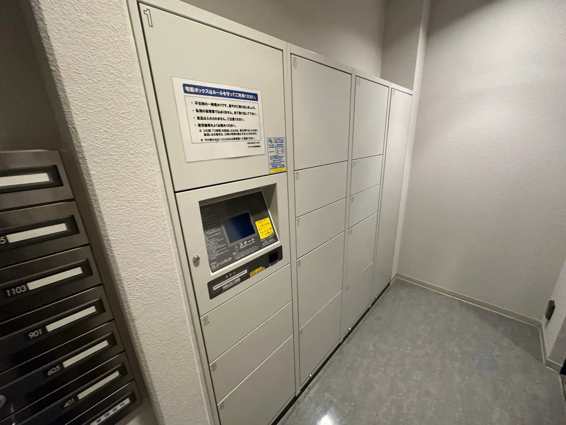 マンションの宅配ボックスとインターホンが備え付けられたエントランスホール