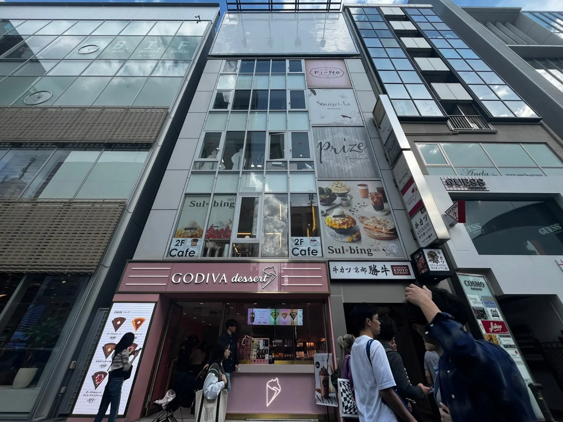ゴディバデザートの店舗と韓国風カフェ「Sulbing」の看板がある現代的な建物ファサード