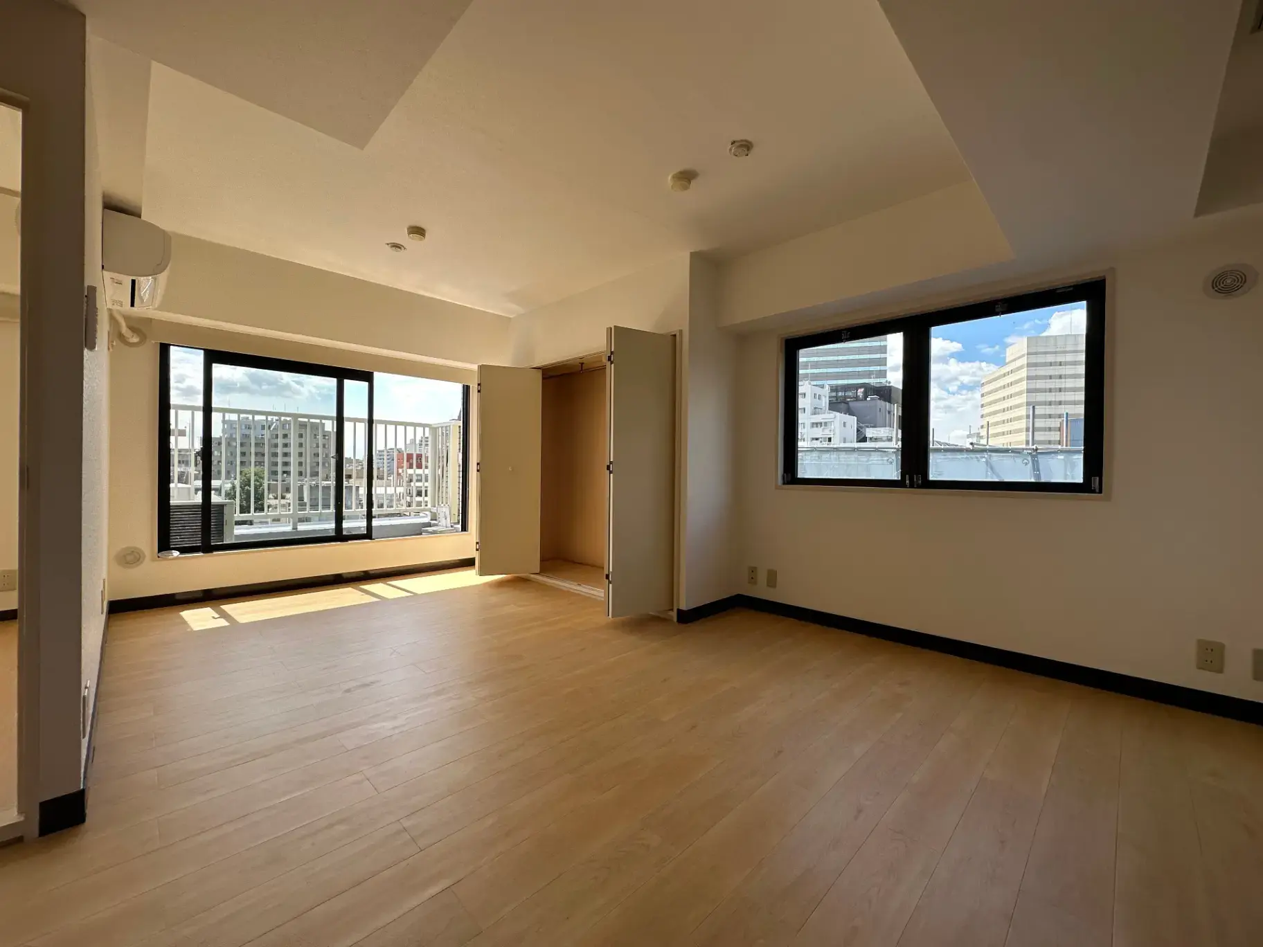 明るい光が差し込む広々としたリビングルーム、都市の景観が望める大きな窓