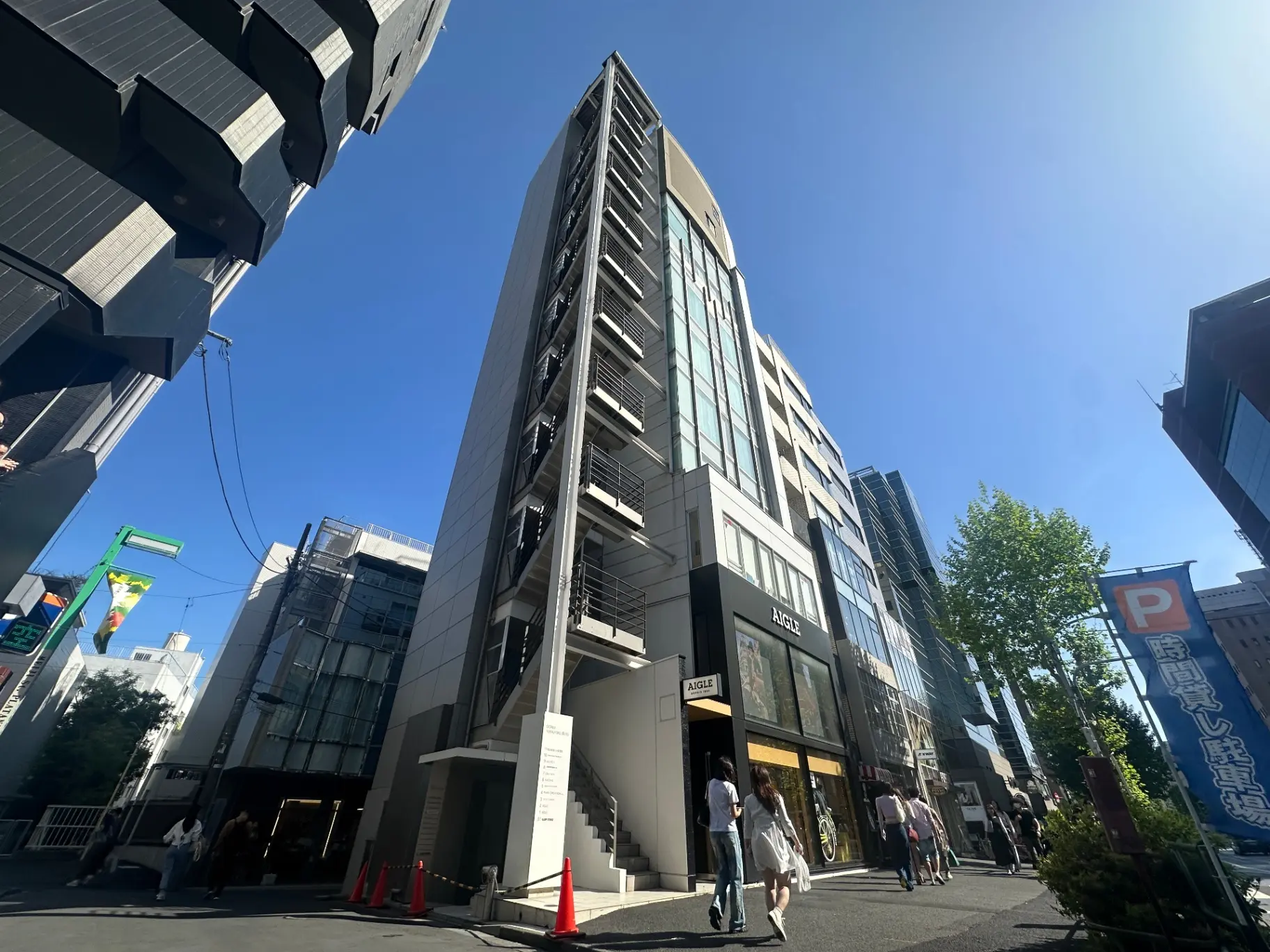都会の高層ビル、青空と建築のコントラスト、人々が歩く街並み