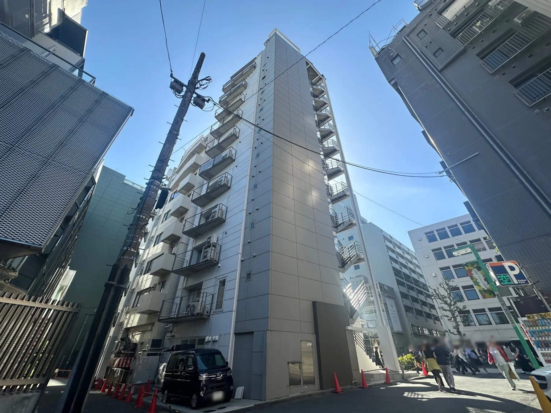 日本の都市風景、狭い路地に立つ高層アパート、青空と電信柱