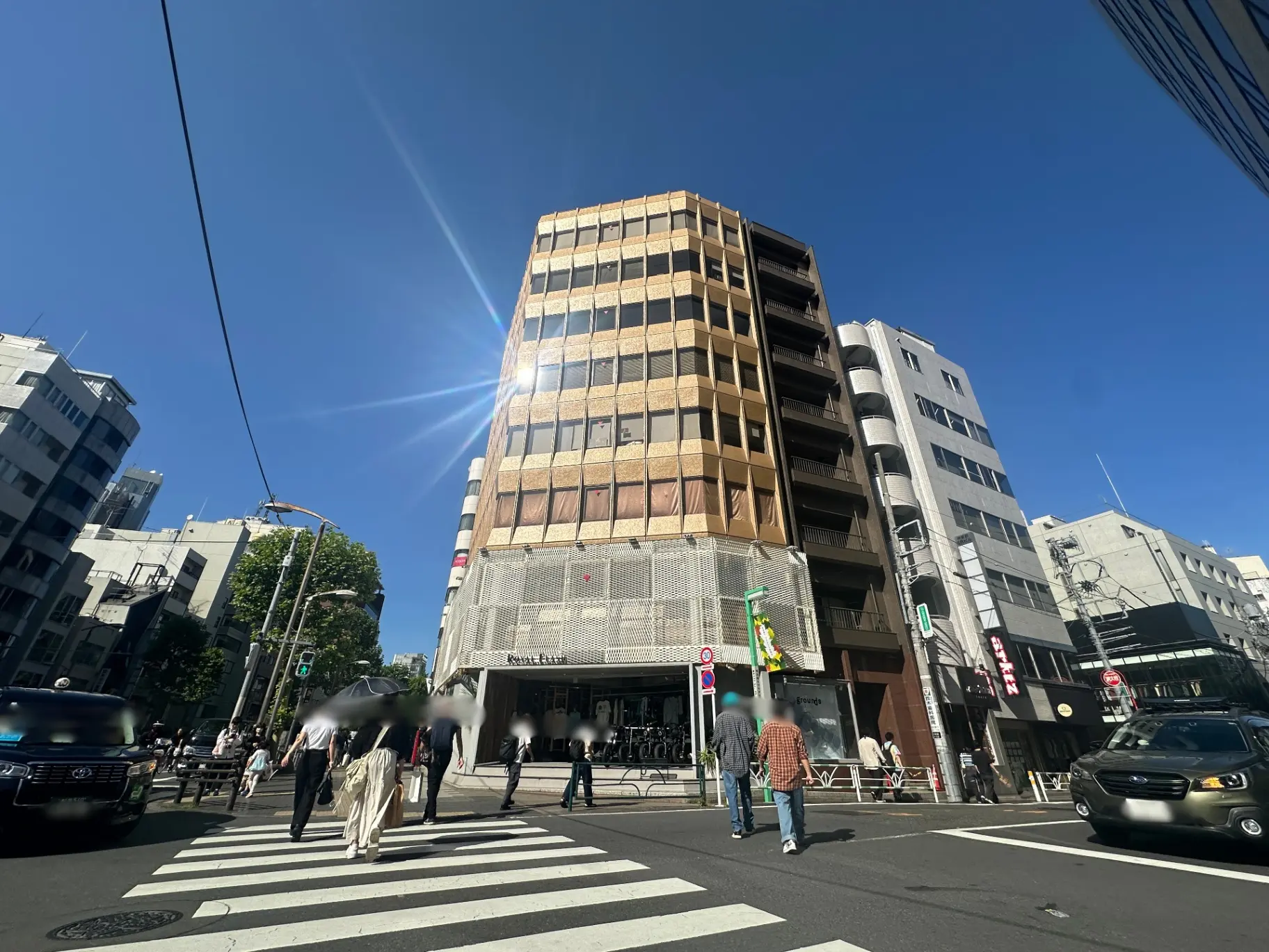 日本の都市風景、交差点での歩行者と車、晴天の下でのビルの外観