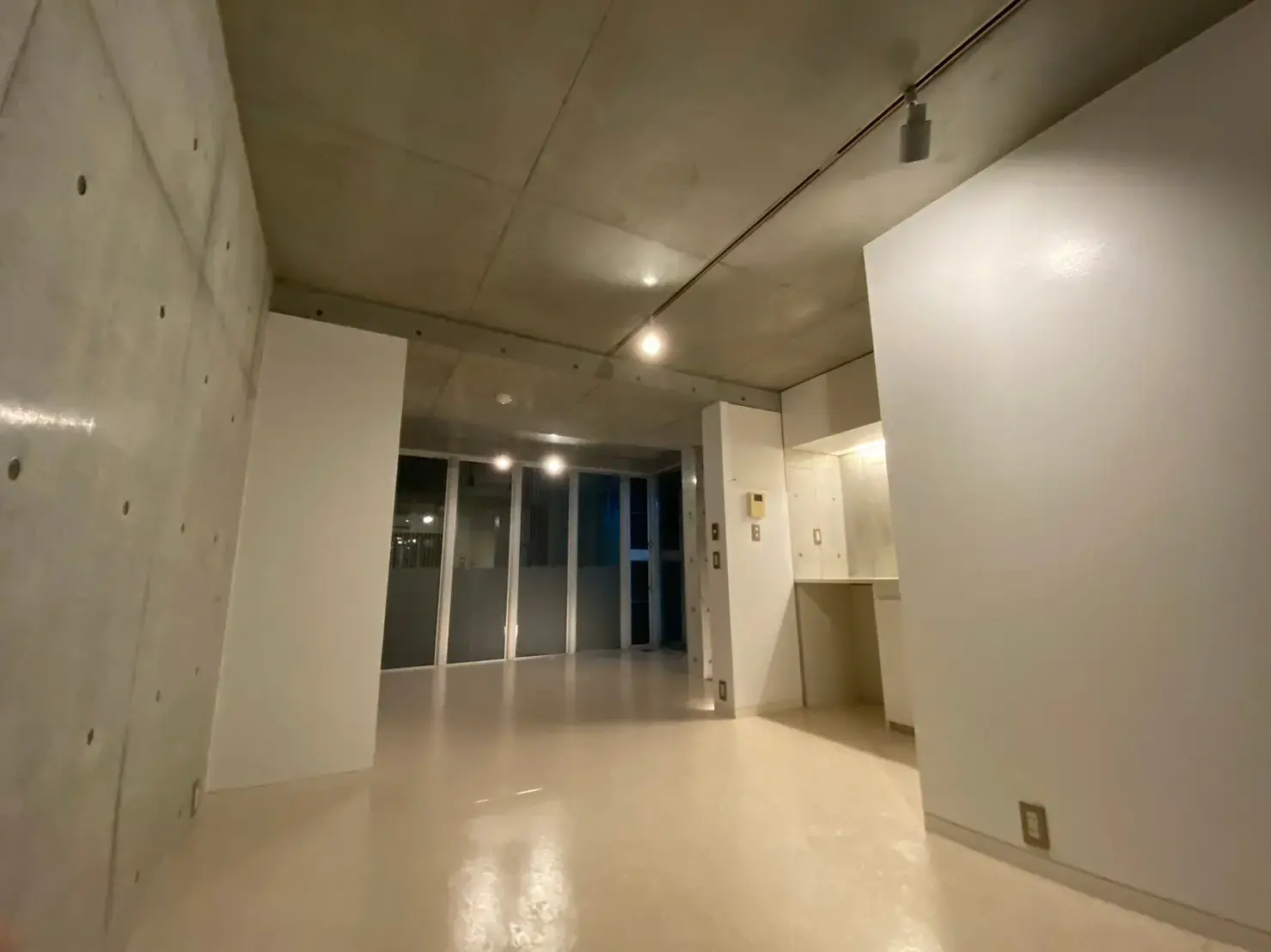 コンクリート打ち放しのモダンな空間、白い壁と床、シンプルな内装の部屋
