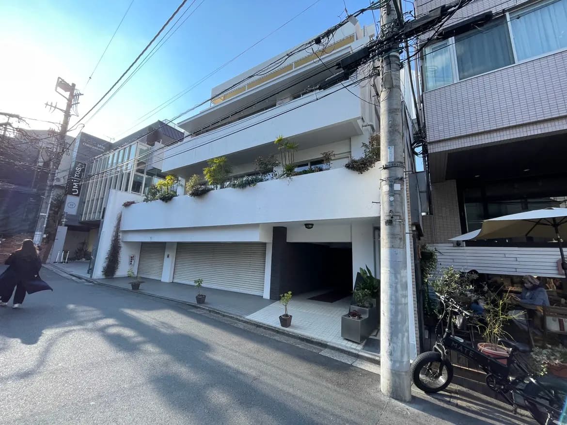 都市の日当たりの良い通り沿いにあるモダンなデザインの建物と小さなカフェのテラス