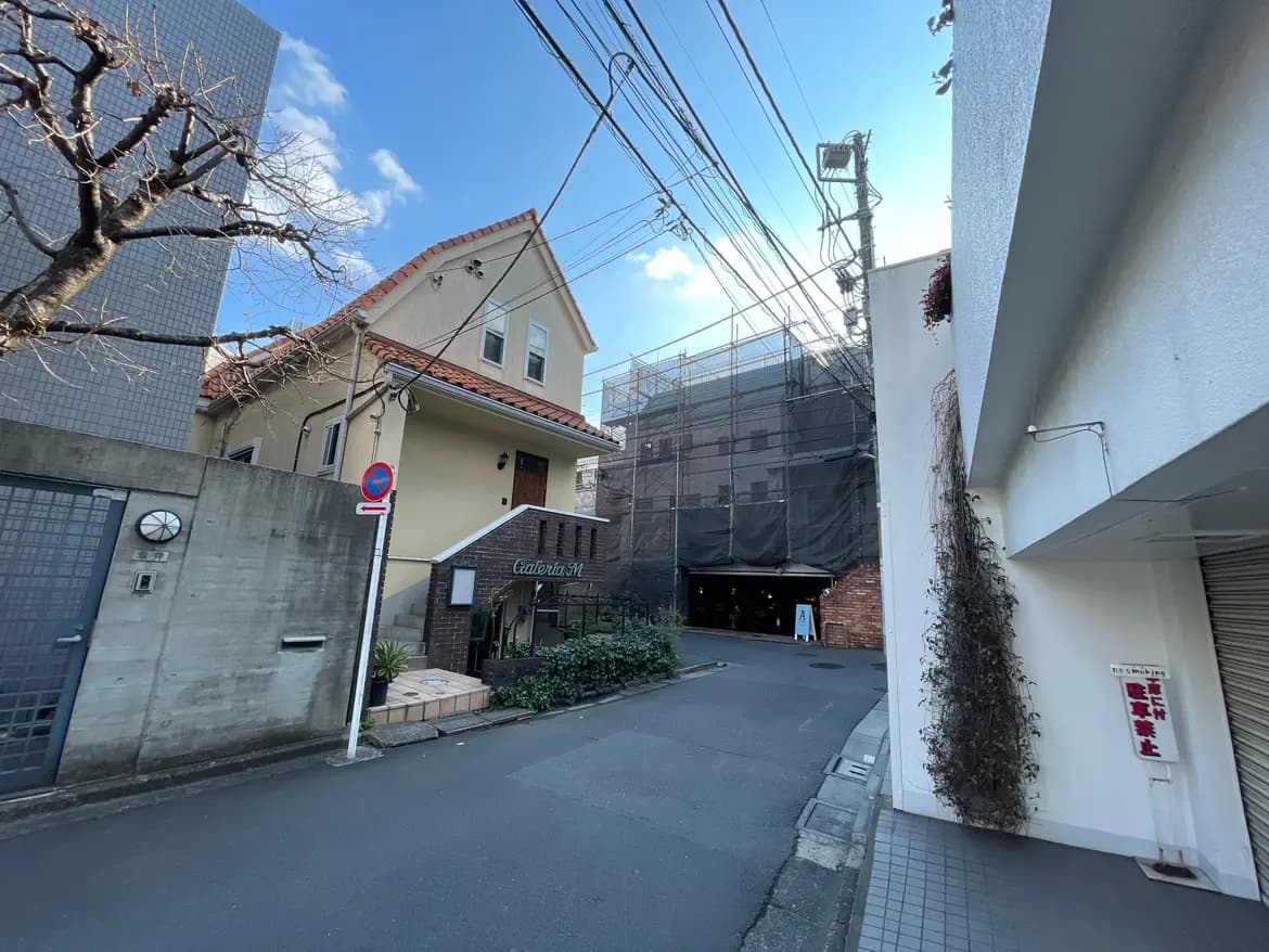 日本の住宅街の景色、道路標識が見える狭い路地と建築中の建物