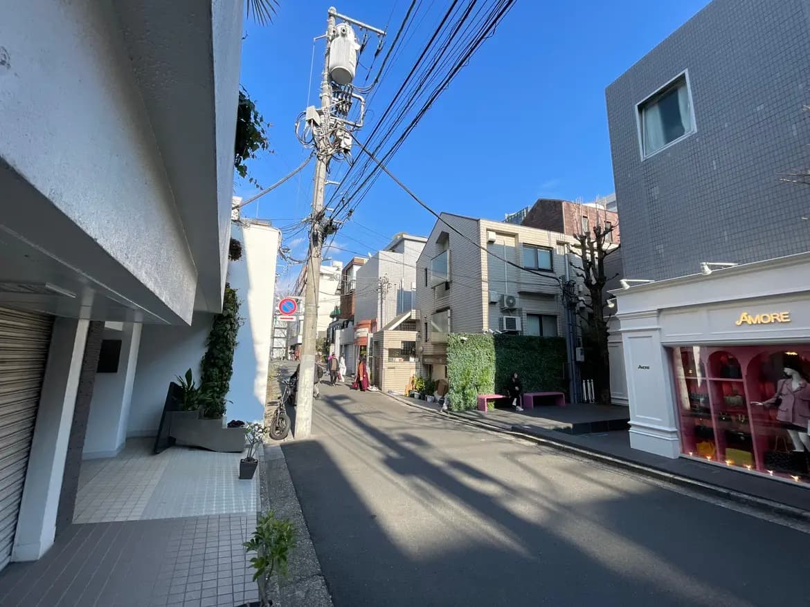 晴れた日の都市部の狭い路地、電柱と配線が目立つ都会の風景