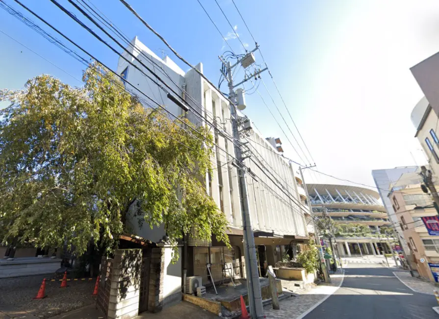 都市の風景、電線が絡まるビルと街路樹、晴天の空と青空