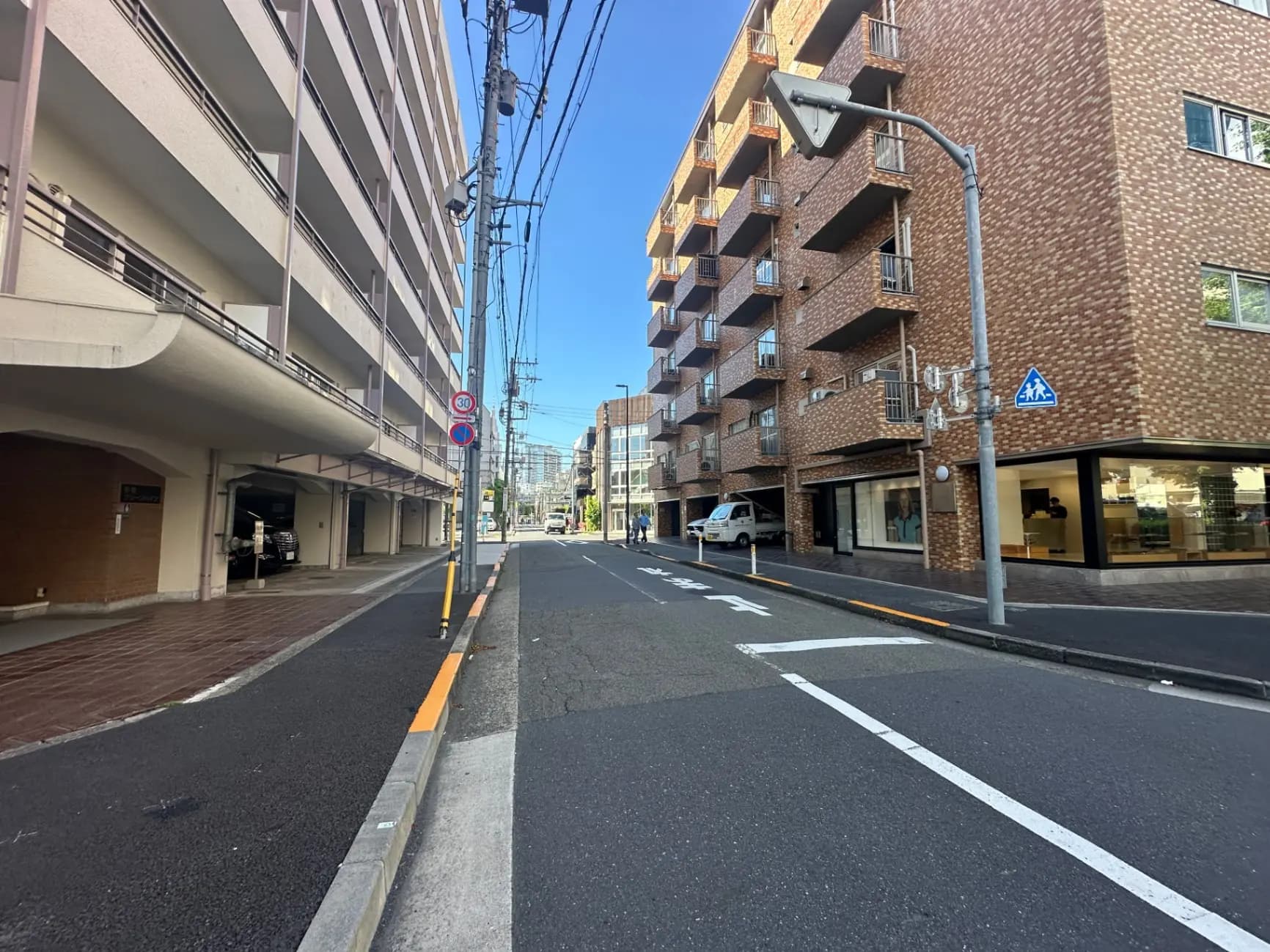 都市のアパート街並み、晴れた日に撮影された歩道と路上駐車スペース