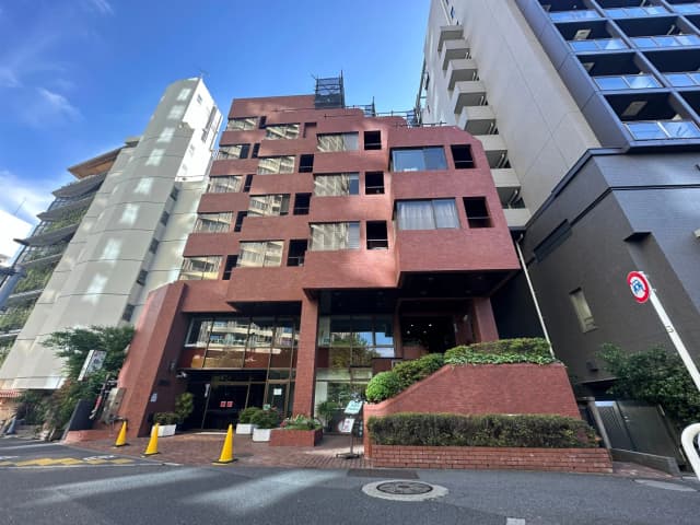 赤茶色の外壁が特徴的な現代的な建築物、都市景観に溶け込むマンションのエントランス