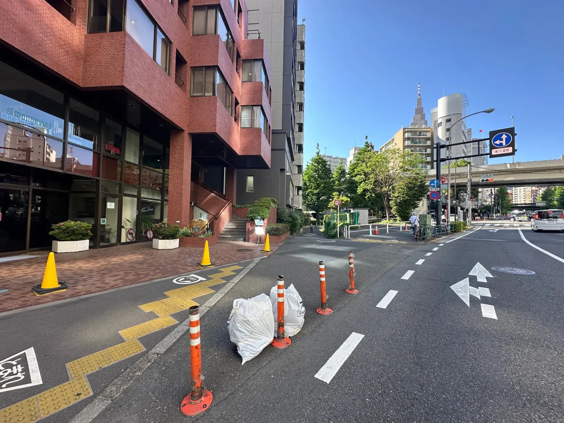 日本の都市部の交差点と赤煉瓦の建物、信号機、自転車のある風景
