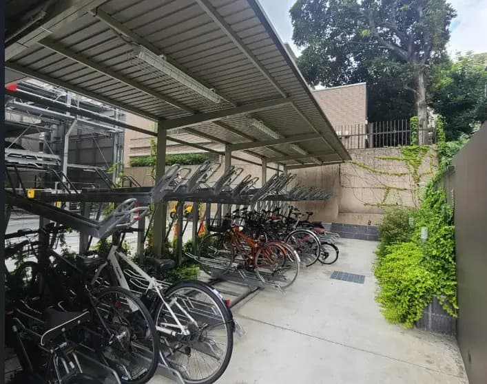 屋根付き自転車駐輪場、二段式ラックと植栽がある都市型駐輪スペース