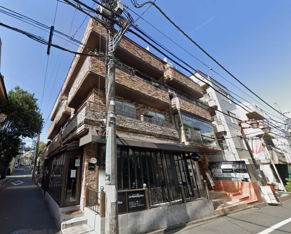 日本の都市部にある煉瓦造りの複合商業ビルと周辺の電柱や電線