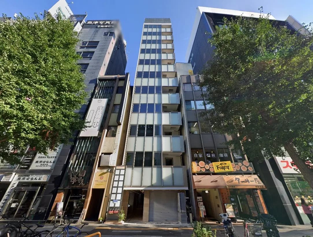 日差しが降り注ぐ市街地に位置するモダンな建物群、商業施設とオフィスが混在する街並み