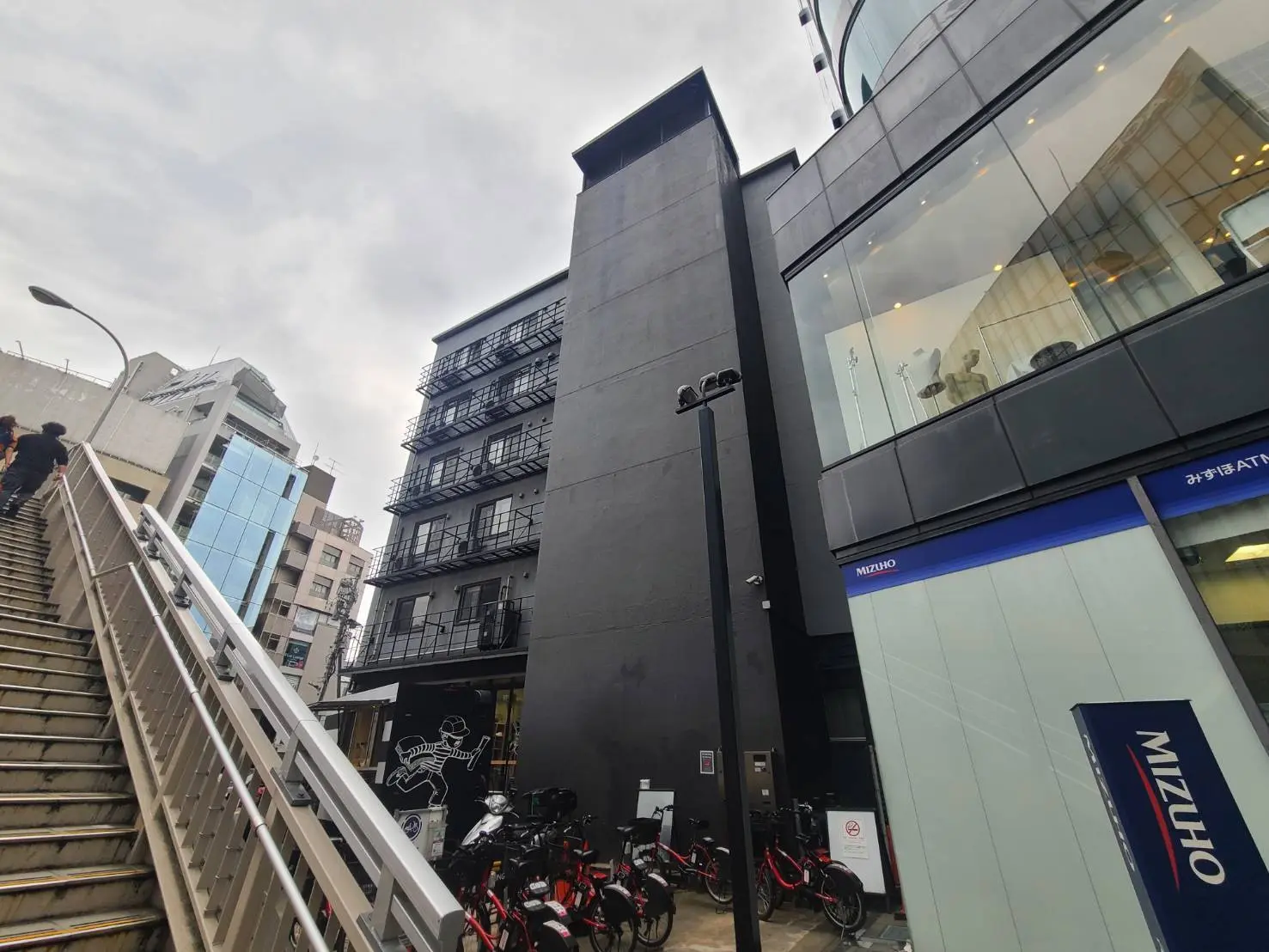 現代的な建築スタイルのビルと階段、ガラス張りのファサードと黒いファサードの建物、都会の風景