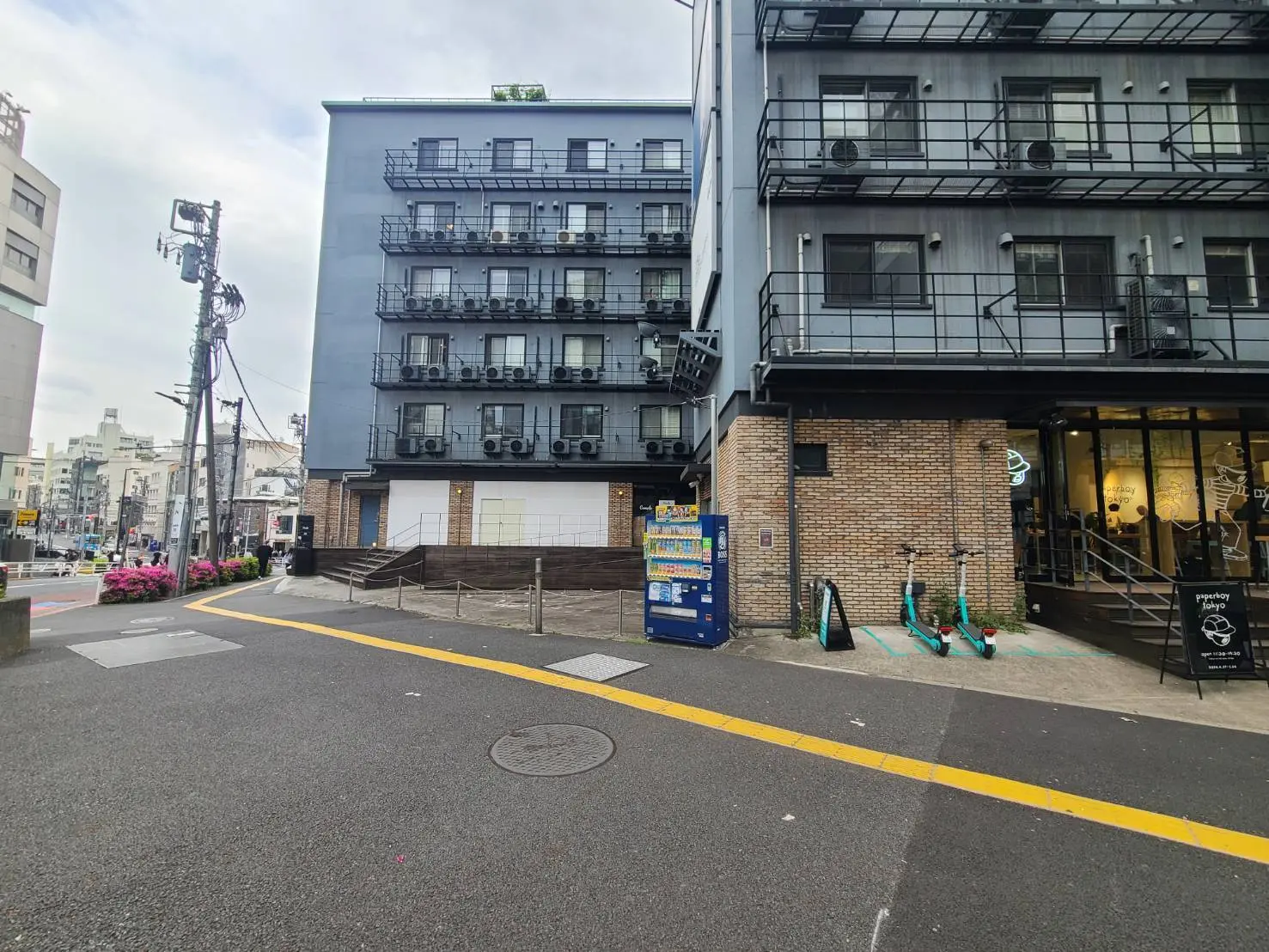 都市のコーナーにある現代的な建物、ストリートビュー、歩道と電動キックスクーター