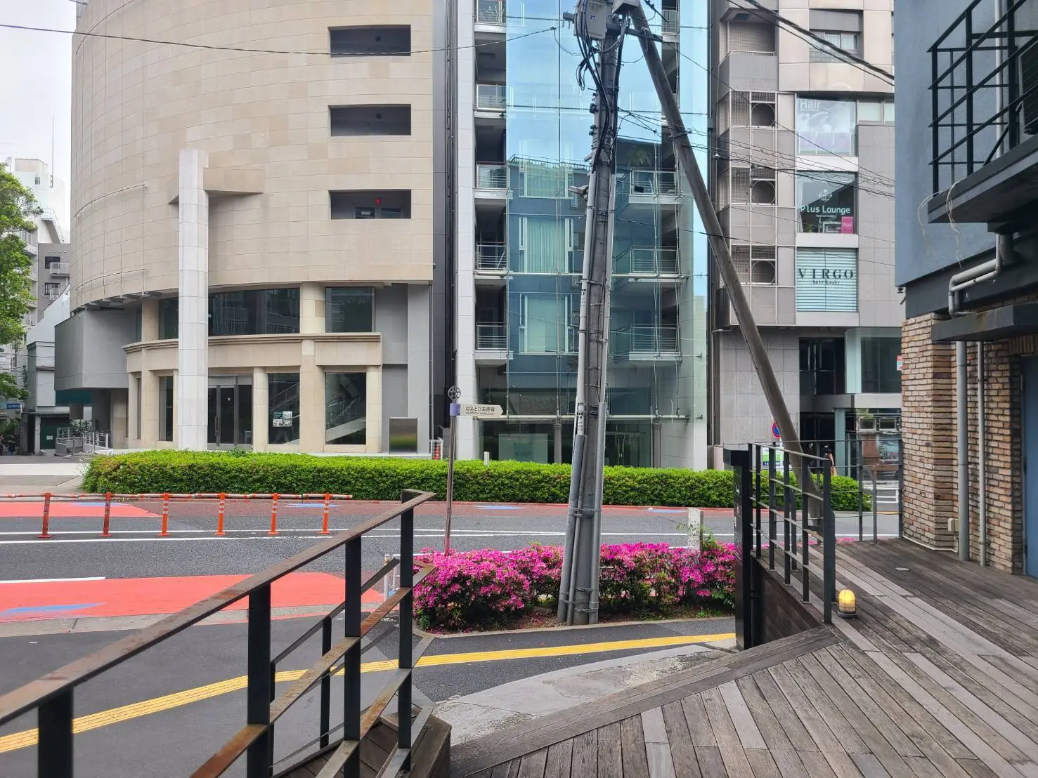 都会的な街並み、木製の階段と花壇、色とりどりの植栽が美しい歩道