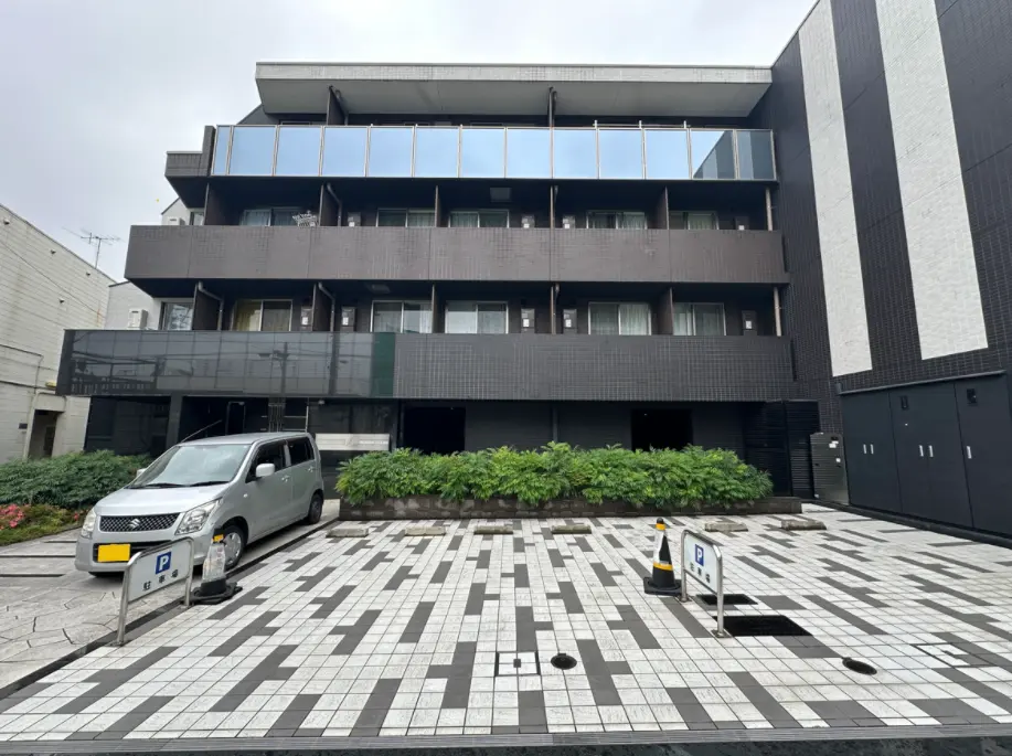 モダンな外観の都市型マンション、黒いタイル張りのファサード、駐車場付き