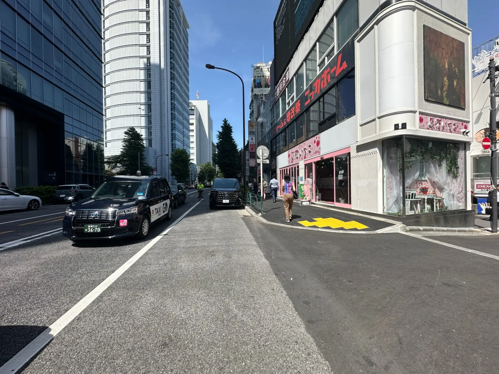 日本の都市部の交差点、タクシーと歩行者、晴れた日の街並み