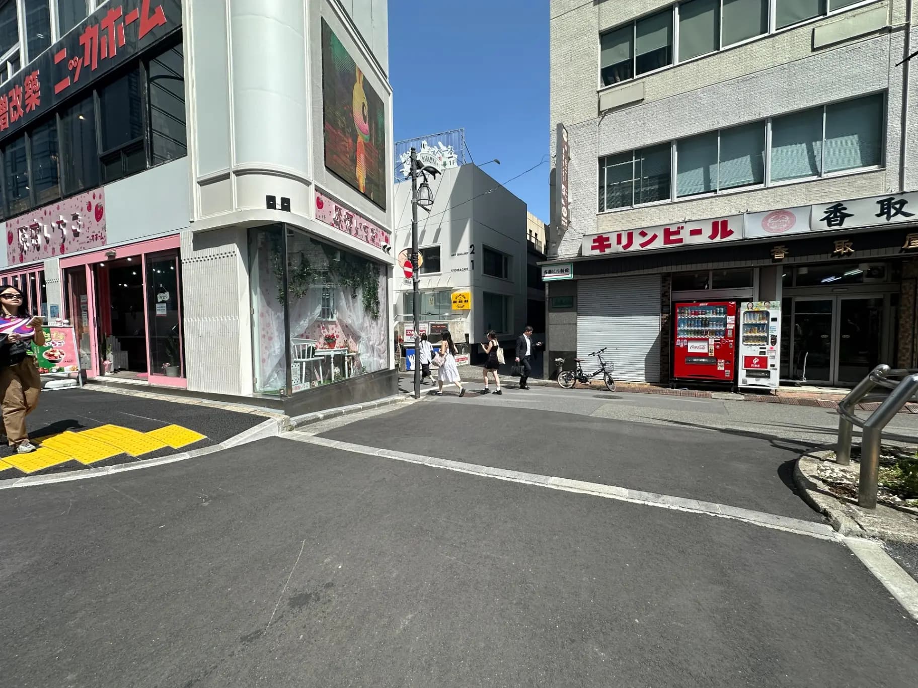日本の都市風景、晴れた日に人々が歩く交差点、路地、店舗と自動販売機