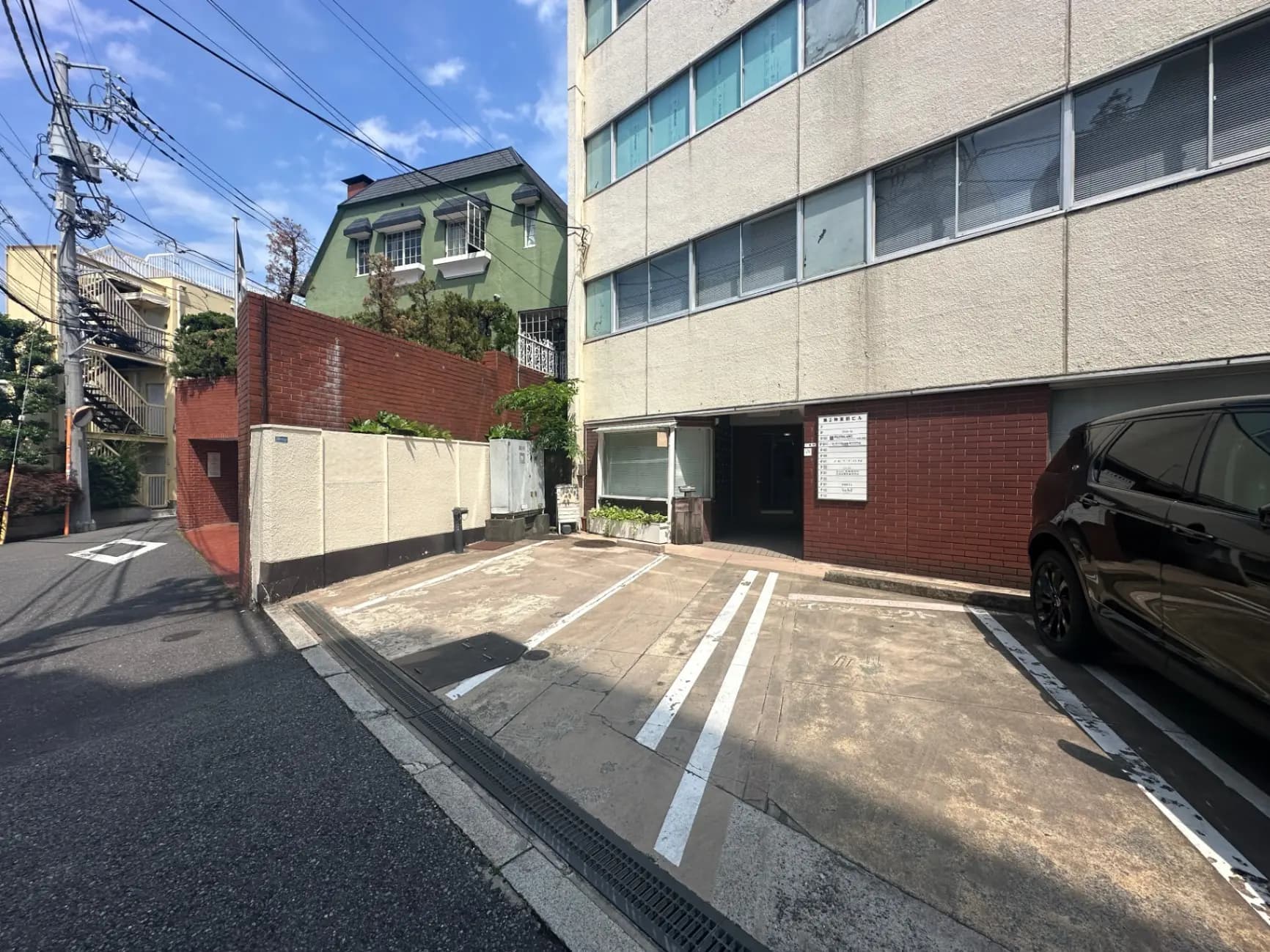 駐車スペースがある都市のアパート建物、晴れた日に撮影