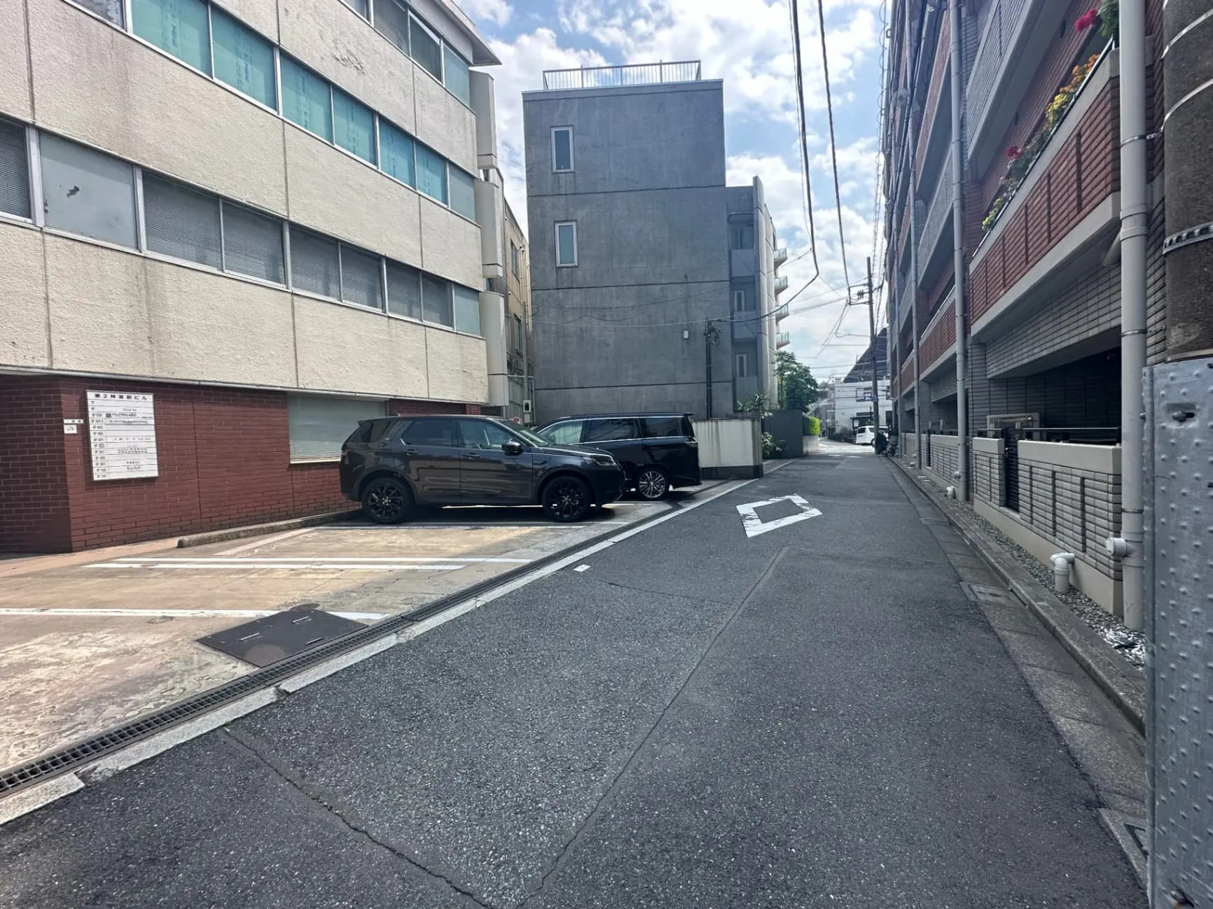 日本の住宅街の静かな路地、ビルとアパートメントが並ぶ景観、晴れた日の都市風景