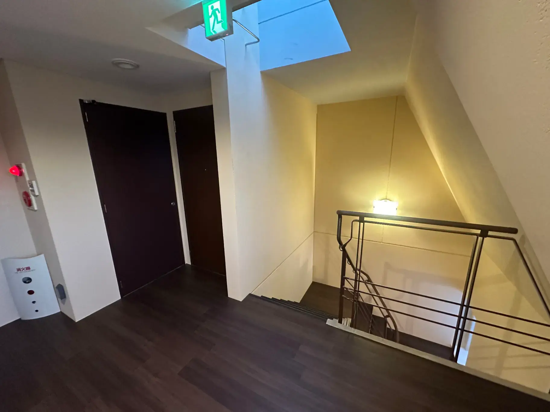 モダンなインテリアの階段と廊下、非常口の看板、天窓からの自然光