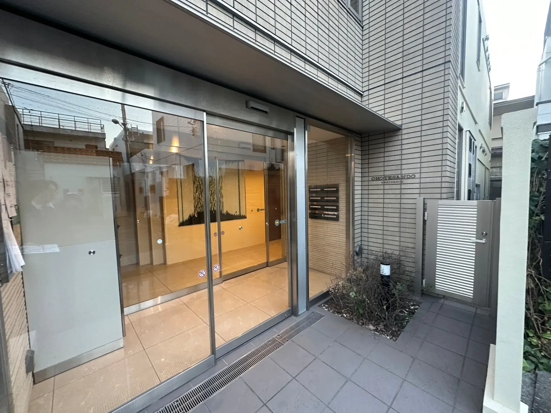 オフィスビルのガラス扉と入り口、外観に会社のロゴ看板