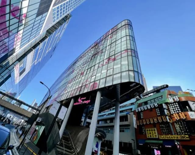 現代的なガラス張りの建物と電子広告、青空の下の都市風景