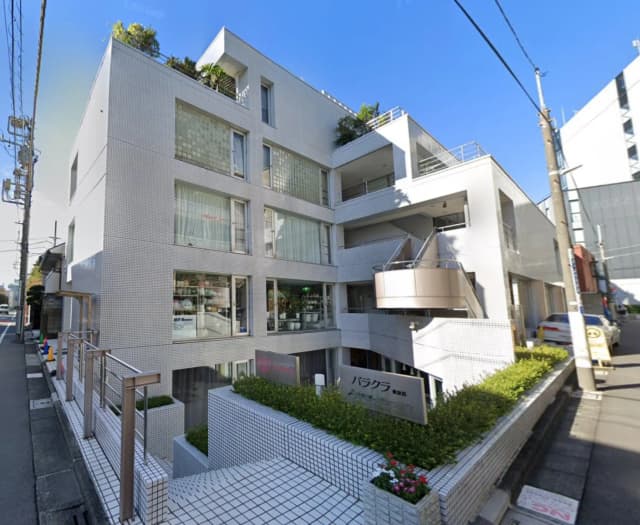 現代的な外観のマンションビル、都市の角地に位置する、植栽付きのバルコニーとクリアなガラス窓