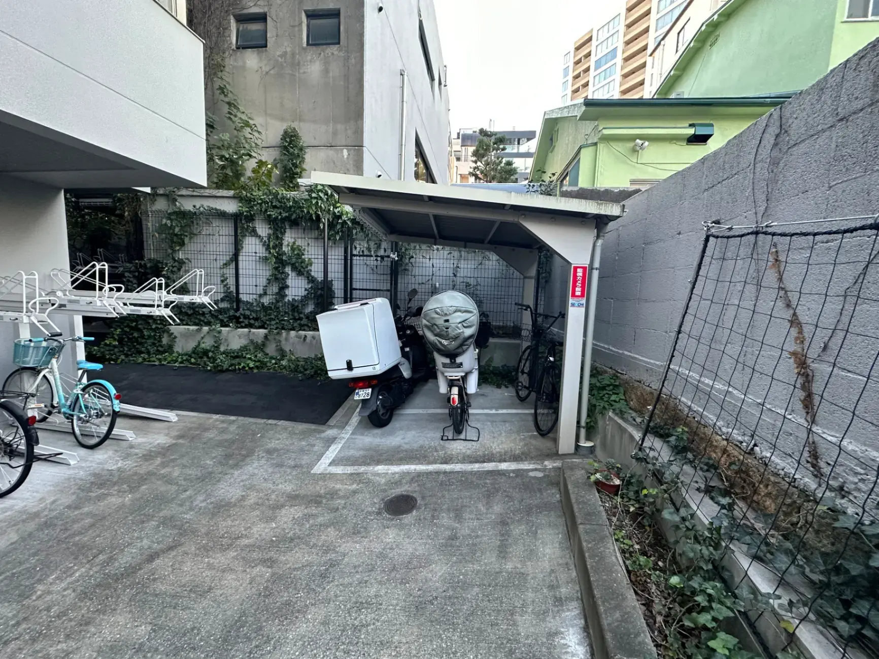 都会のマンションの駐輪場、自転車とバイク、屋根付きパーキングエリア