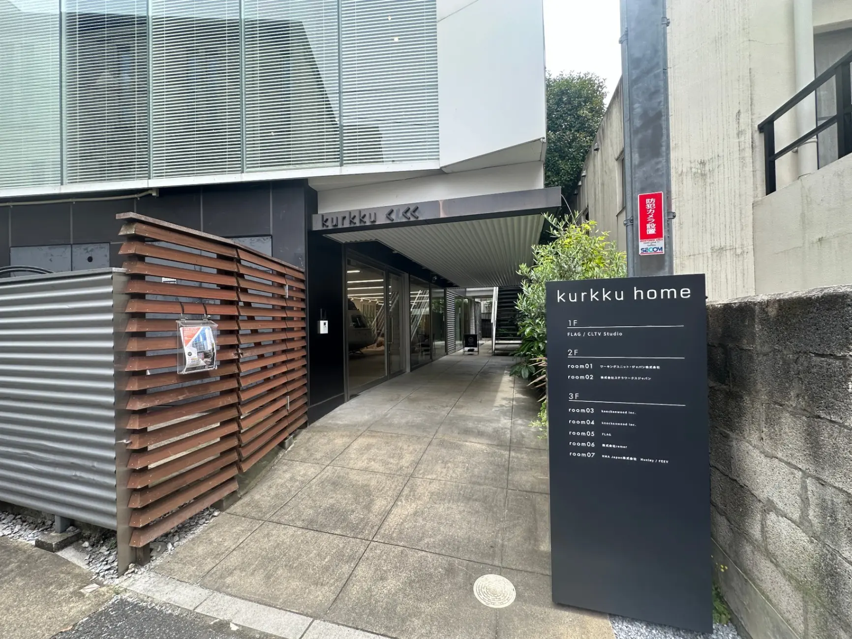 現代的なビルのエントランスと案内看板、都市部のスタジオとオフィススペースを提供するkurkku home