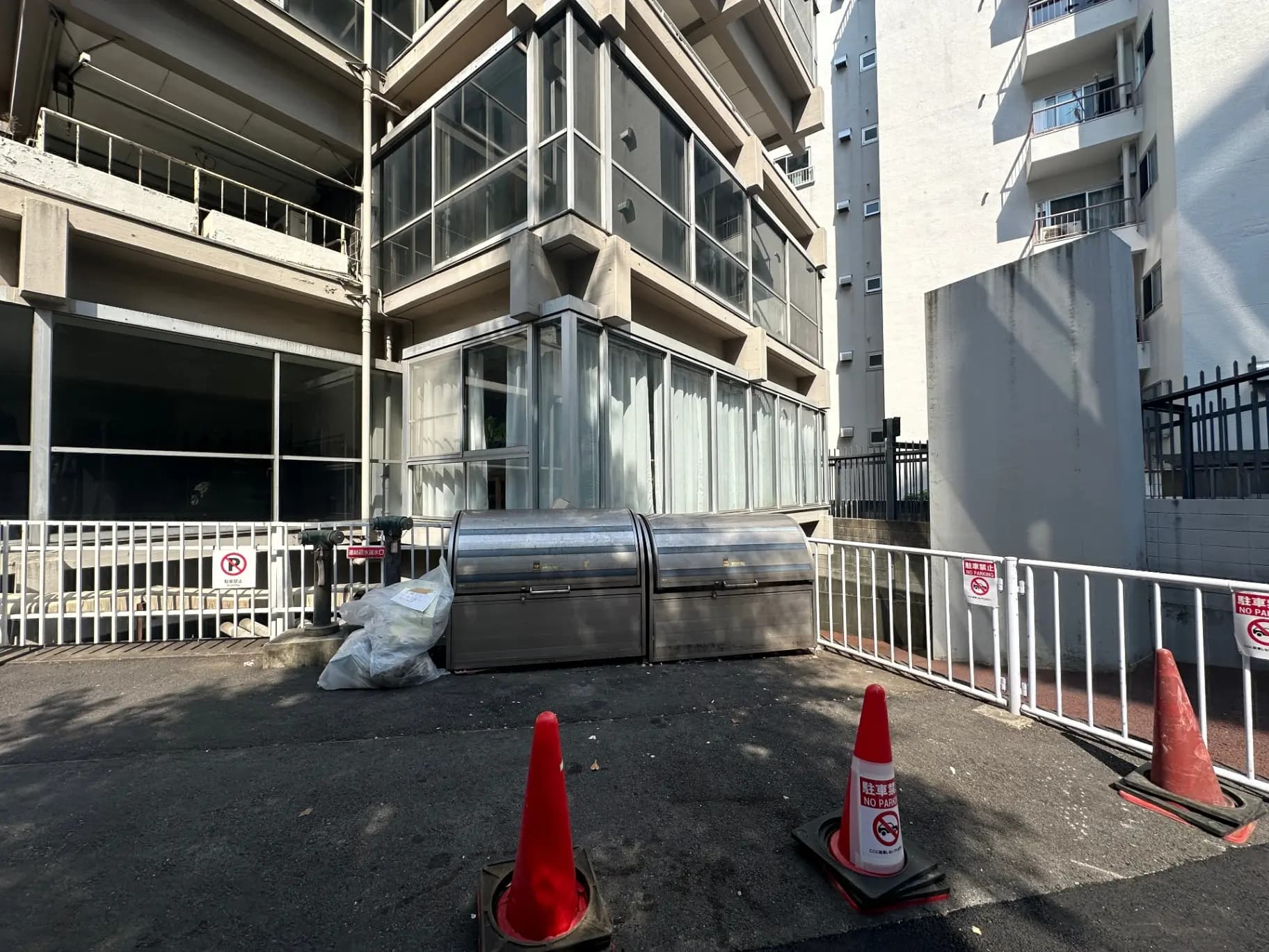 都市のアパートメント建設現場、安全バリケードと工事用コーンが設置された外観