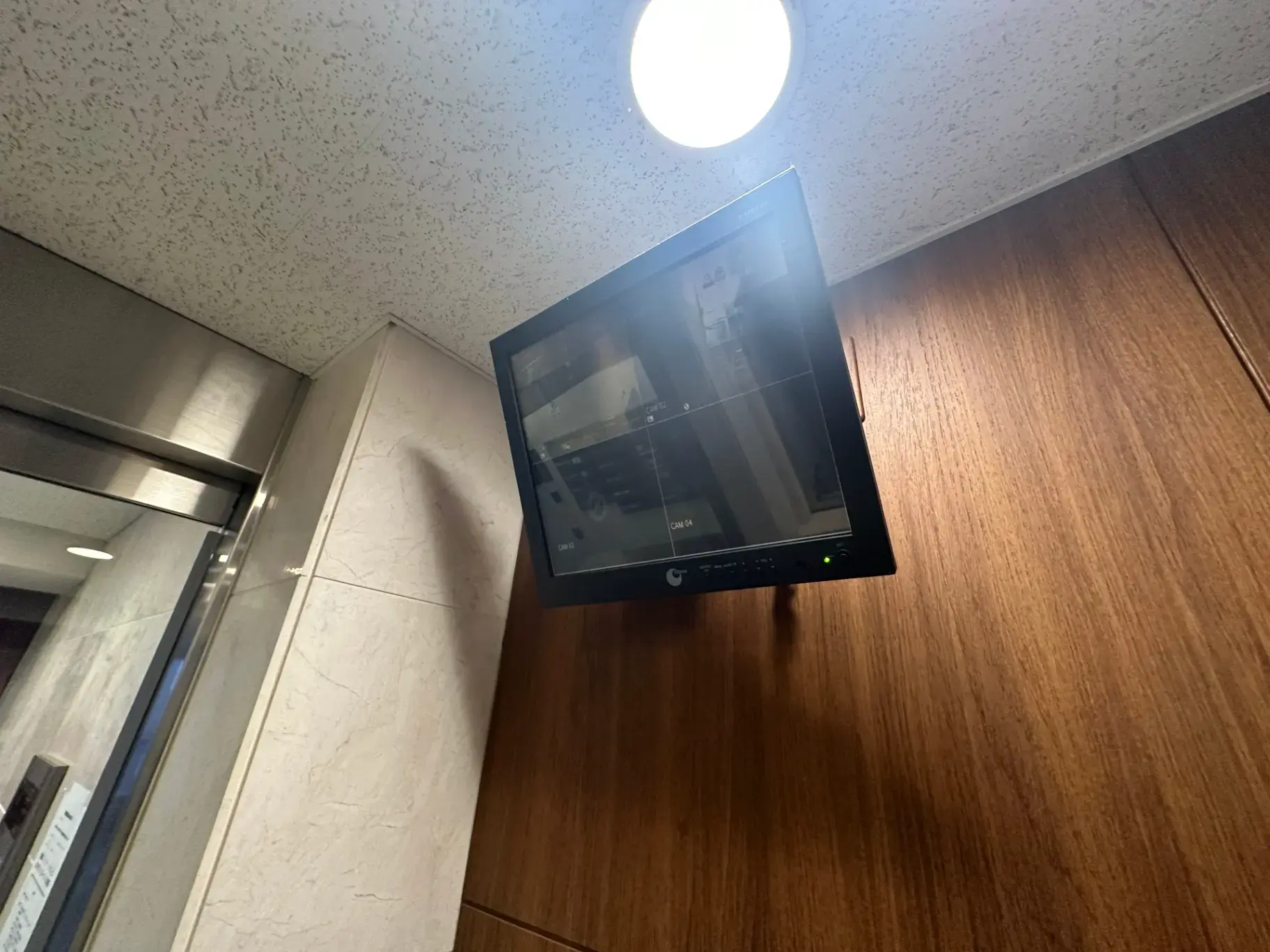 オフィスや商業施設に設置されている監視カメラの映像を表示するセキュリティモニター、壁に取り付けられた状態で稼働中