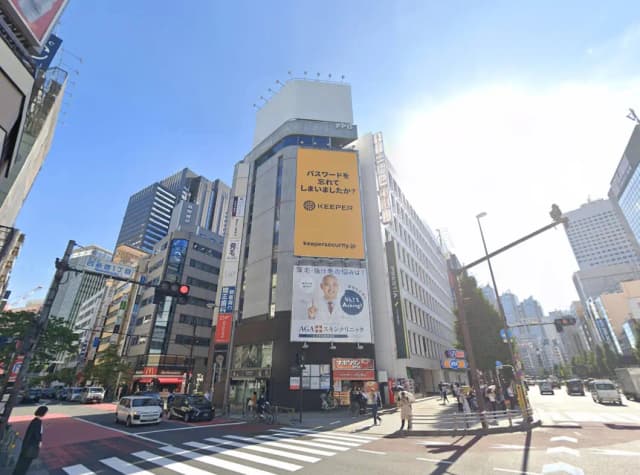 新宿の繁華街にある高層ビル、信号機や街頭広告が見える市街地の風景