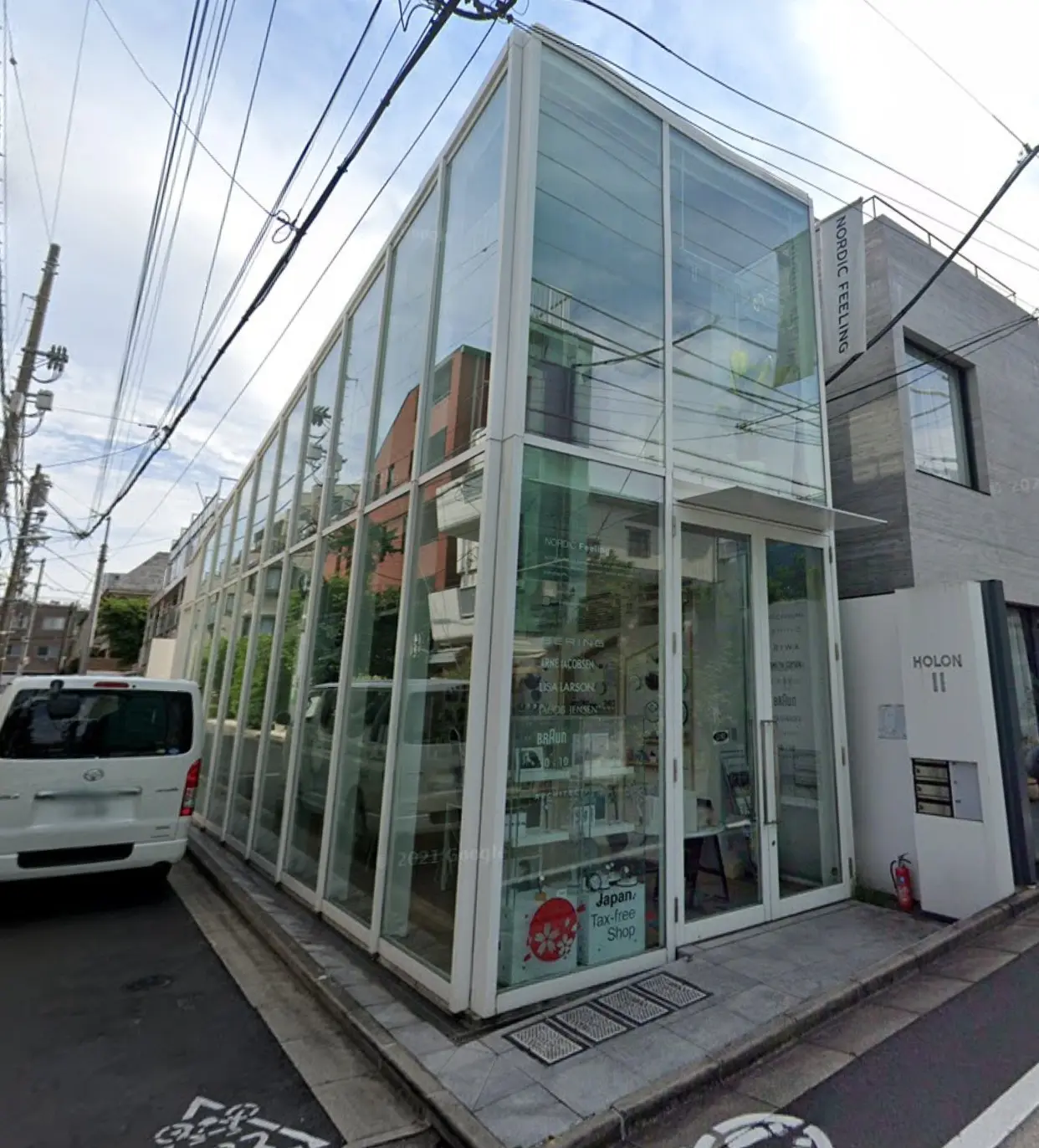 ガラス張りのモダンな外観を持つ都市型ショップ、明るい昼間の街並み