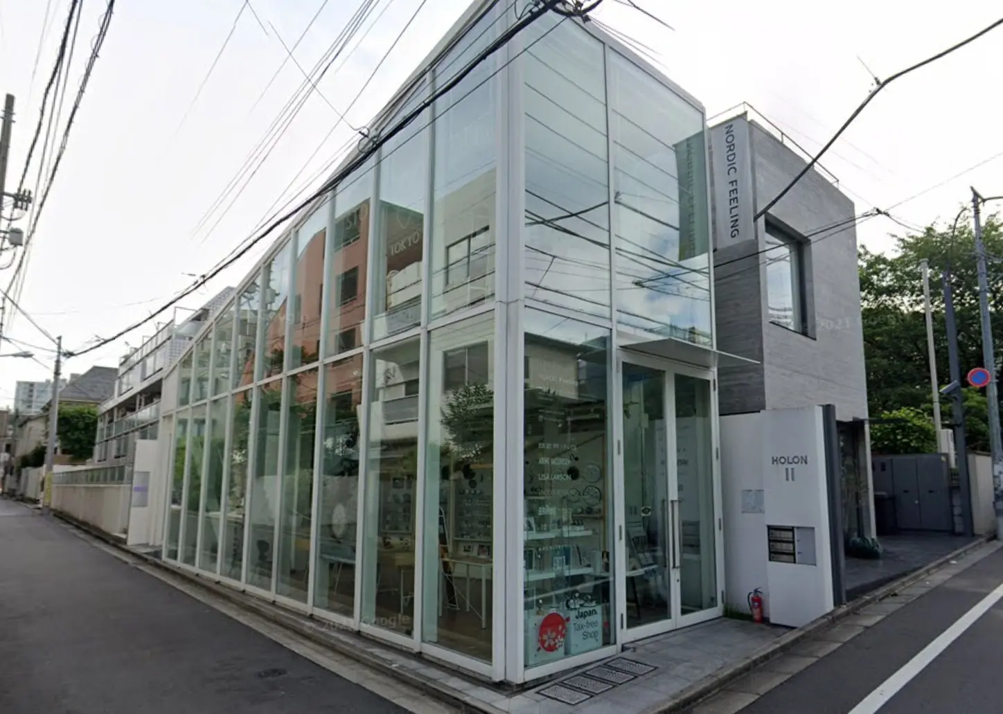 ガラス張りのファサードを持つモダンな建物、都市の角地に位置するショップやオフィスビル