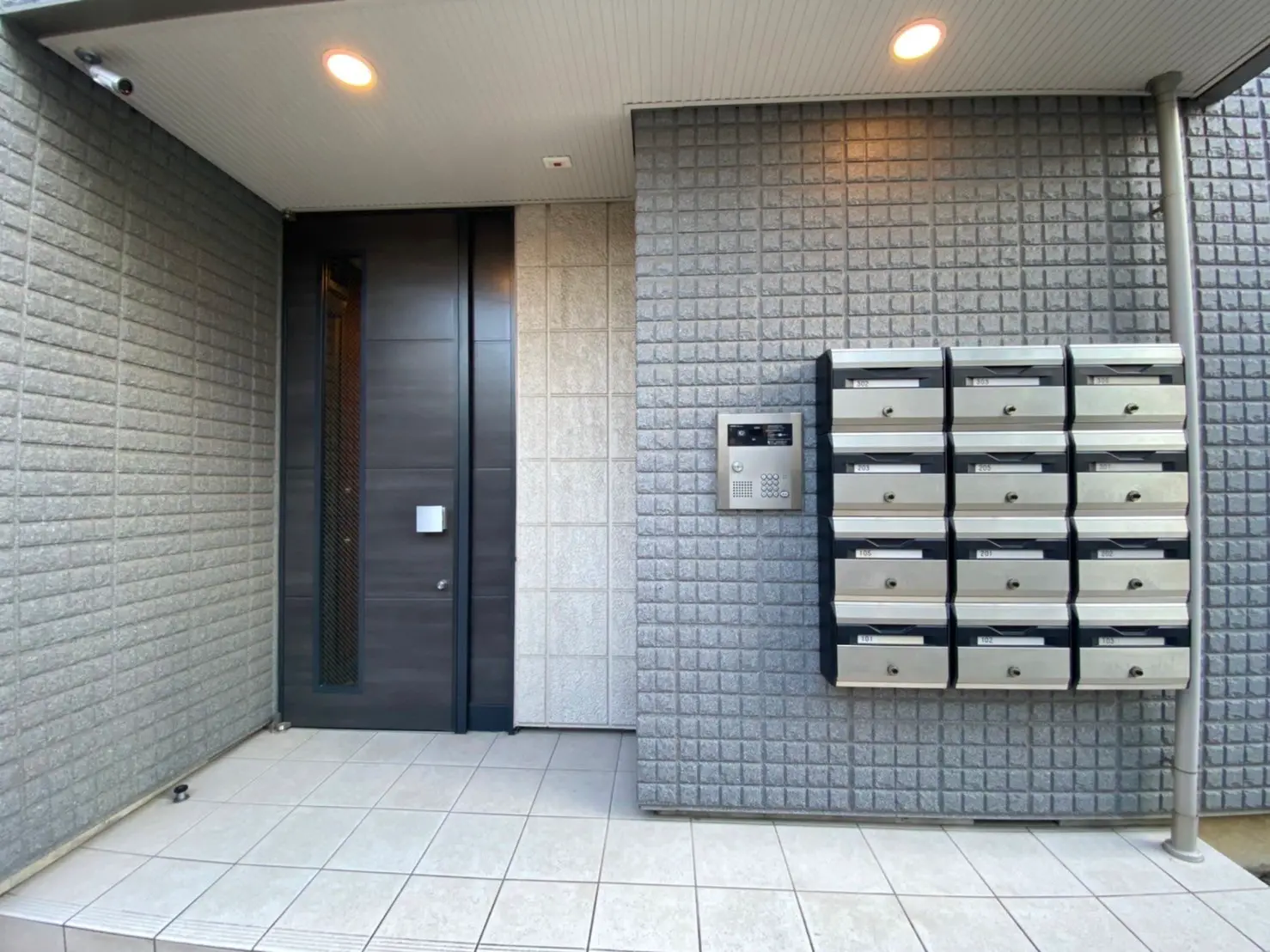 現代的な外観のアパート玄関、郵便受けとインターホンが備わっているエントランス