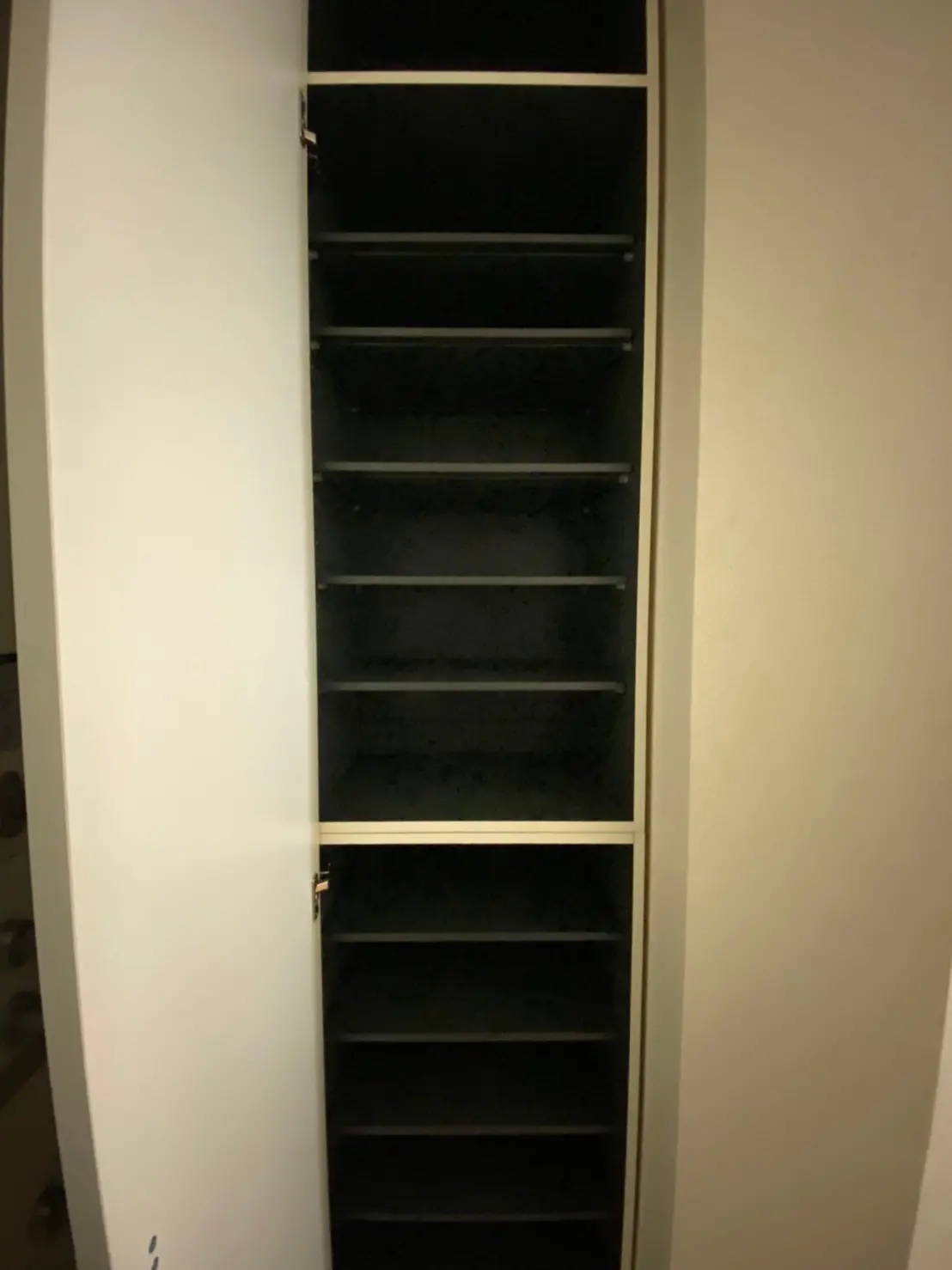 空の白い書棚のドアが開いた状態、暗い部屋のインテリア